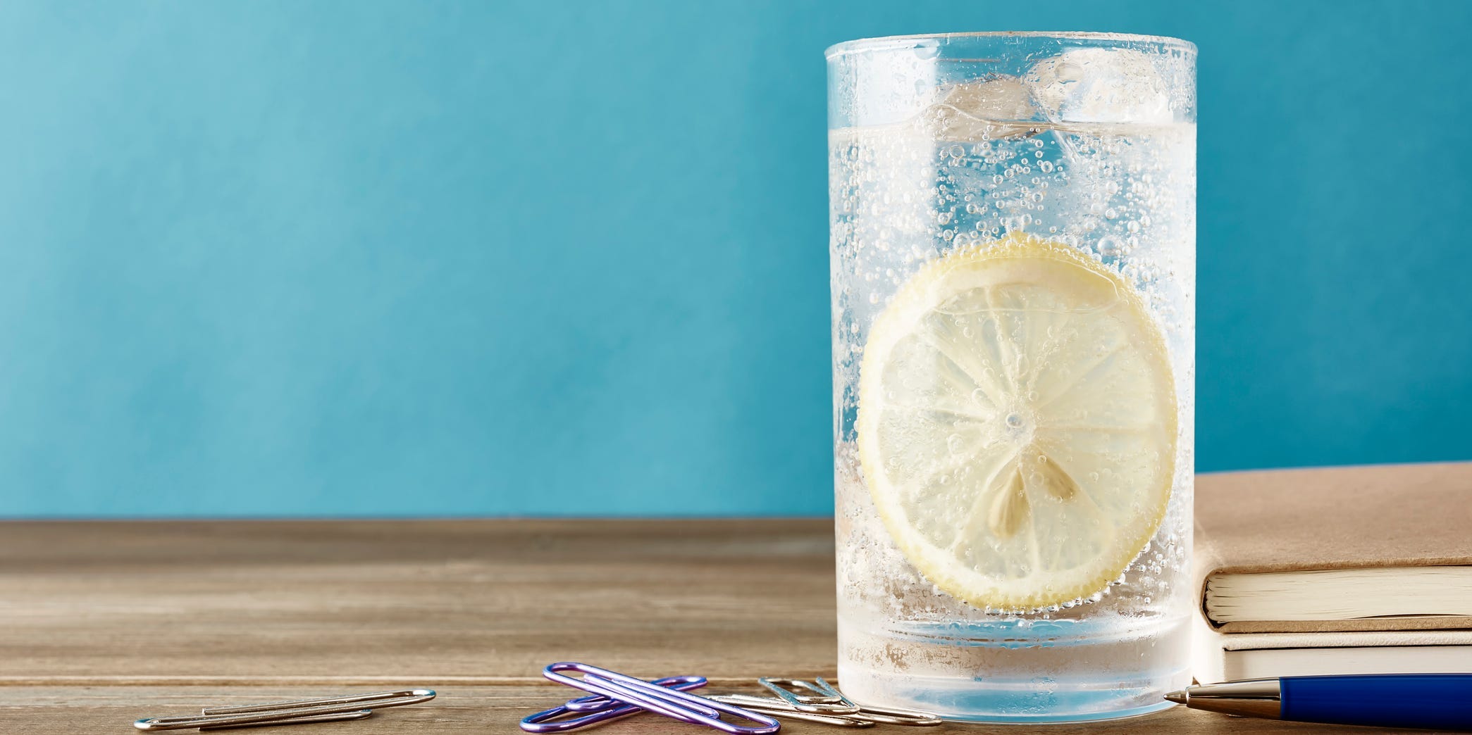 Glass of sparking water with lemon that is framed to the right