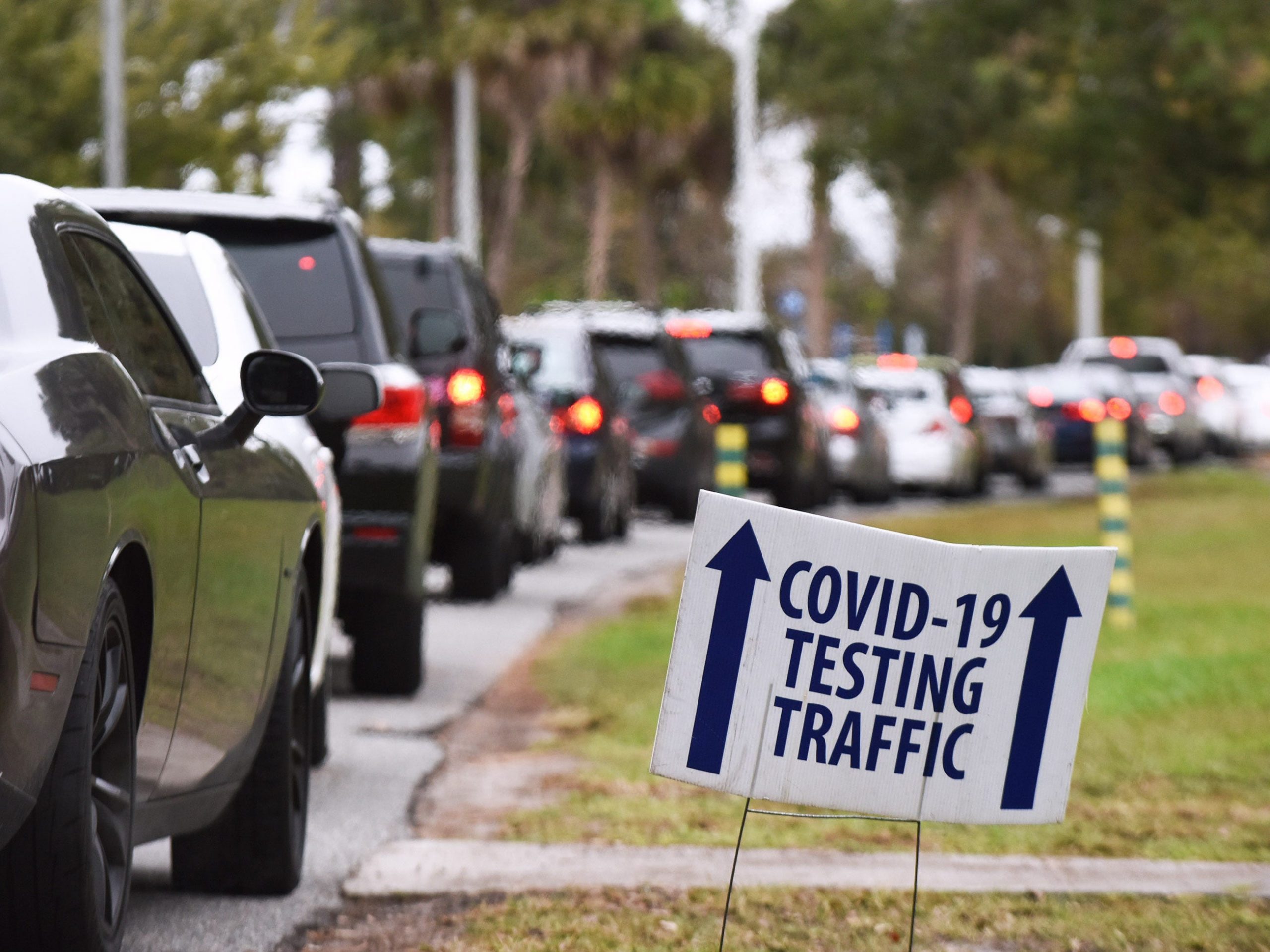 A long line of cars is seen at the entrance to a COVID-19 testing and vaccination site in Barnett Park in Orlando.