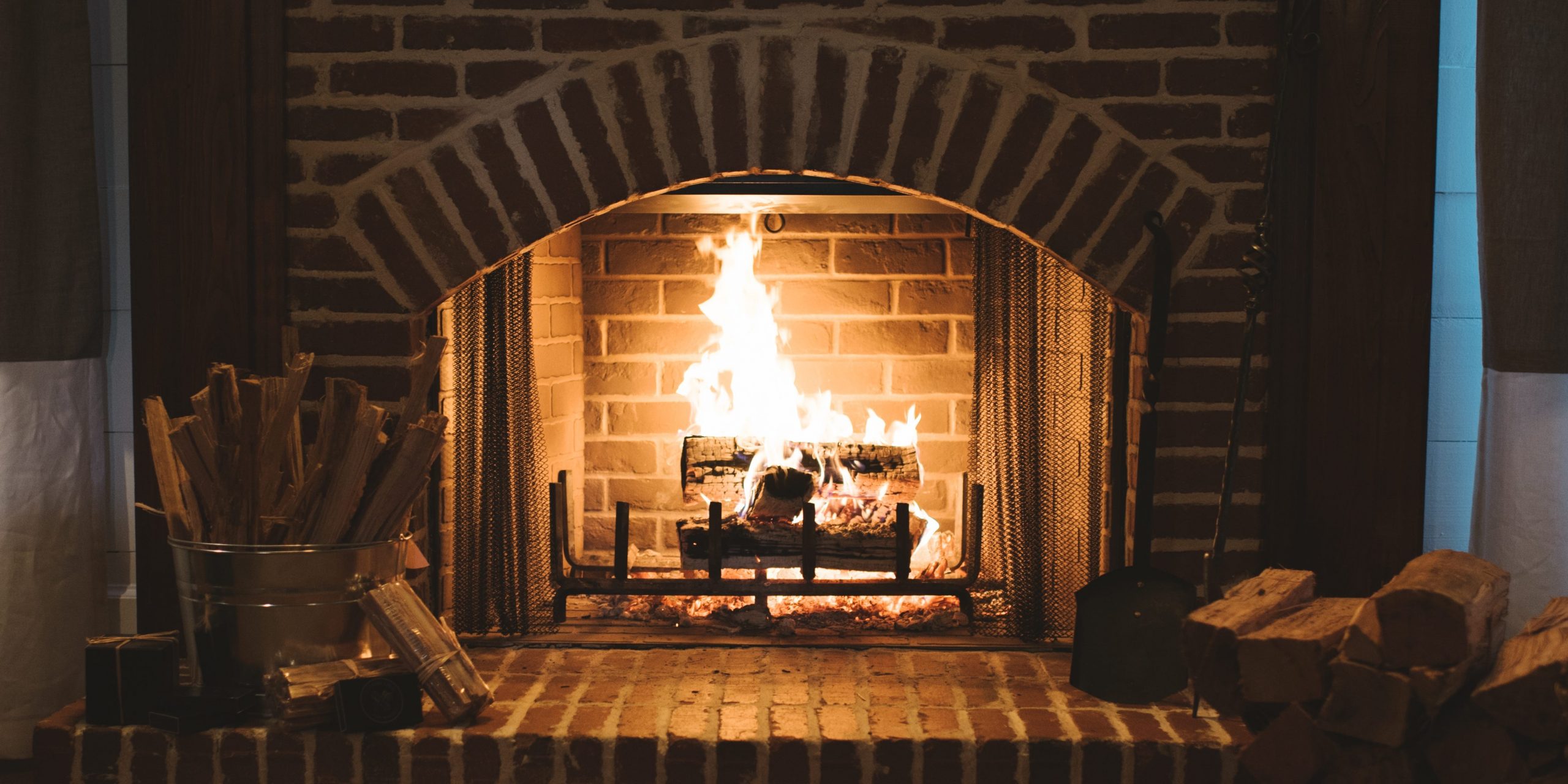 A large brick fireplace with a fire burning inside