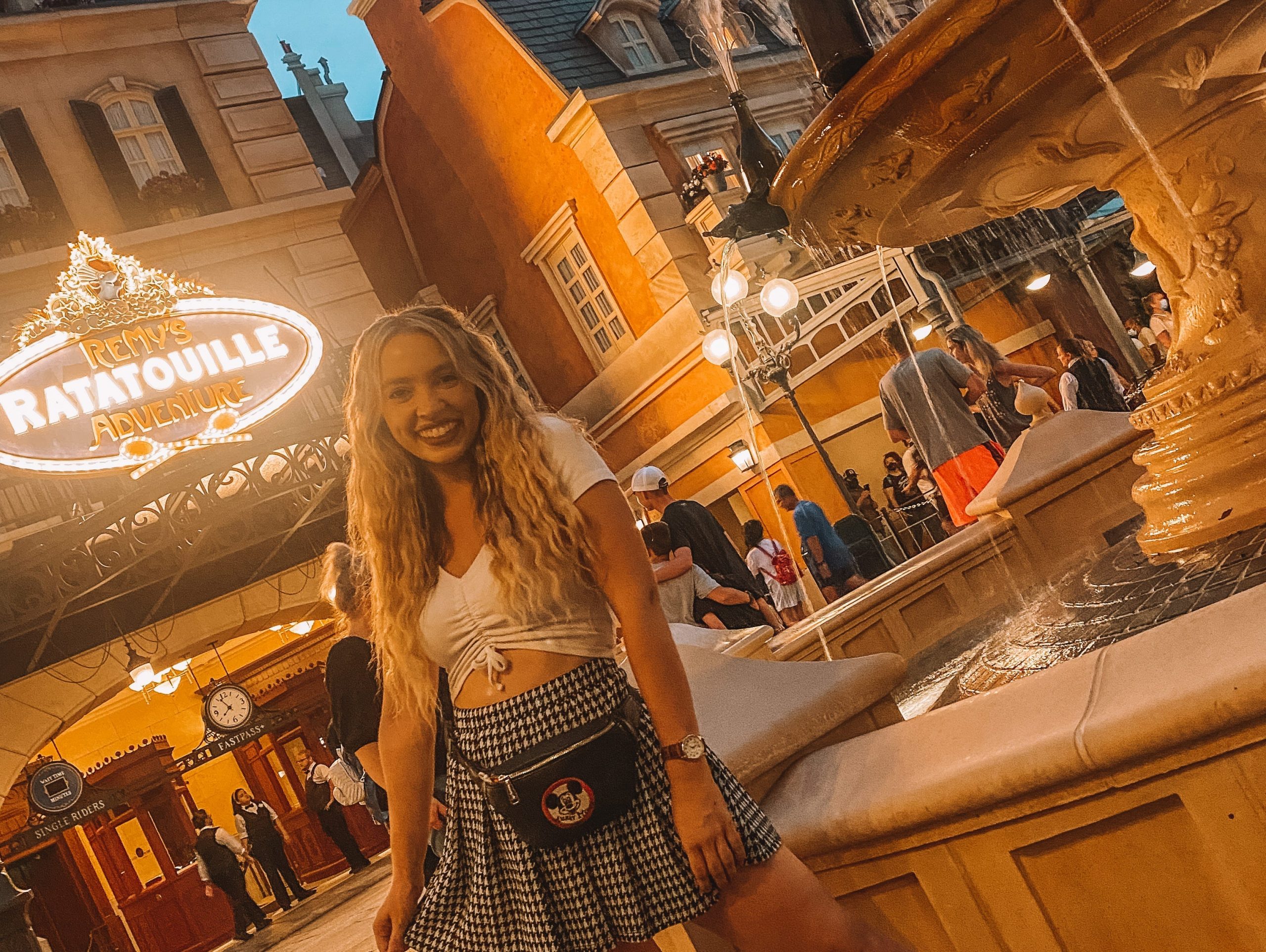 kayleigh in epcot france pavilion in front of sign for remy ratatouille adventure