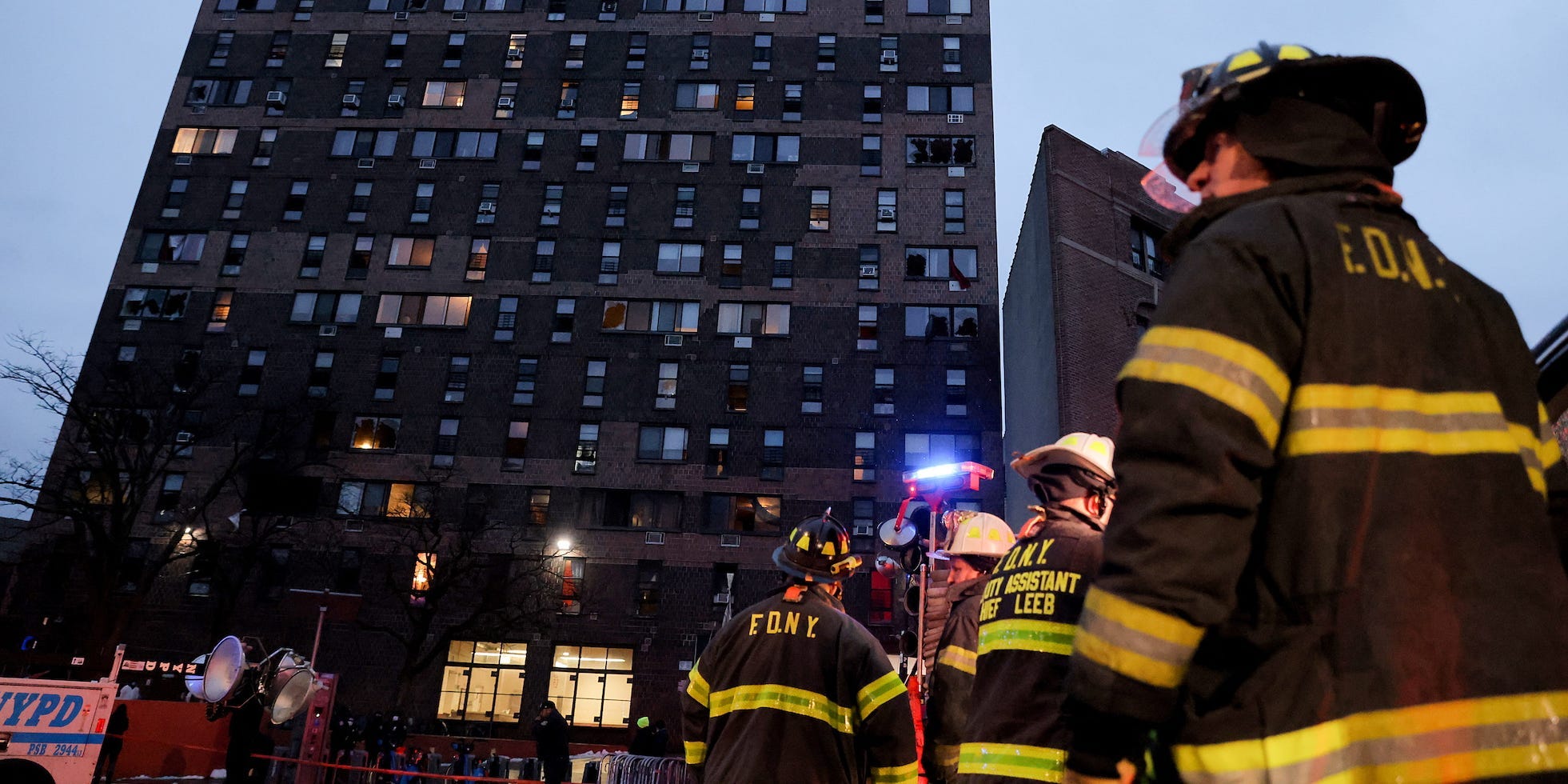 Firefighters stand in front of the building in the Bronx