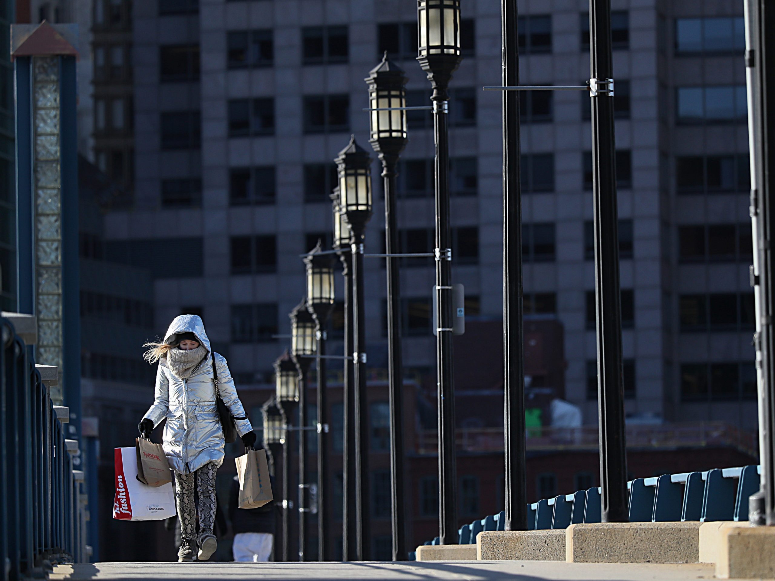 A pedestrian, all bundled up against the cold, walks across the Seaport Blvd Bridge in Boston on March 15, 2021.