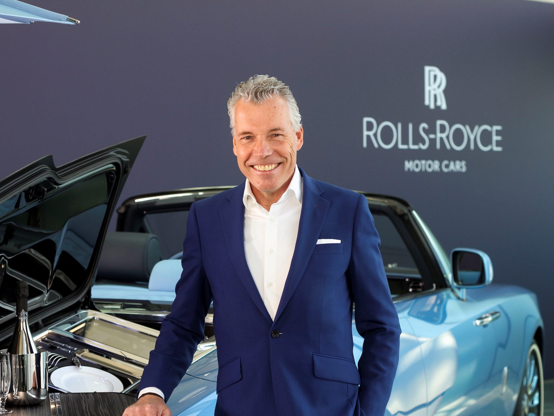 Torsten Muller-Otvos, CEO of Rolls-Royce, poses next to a car