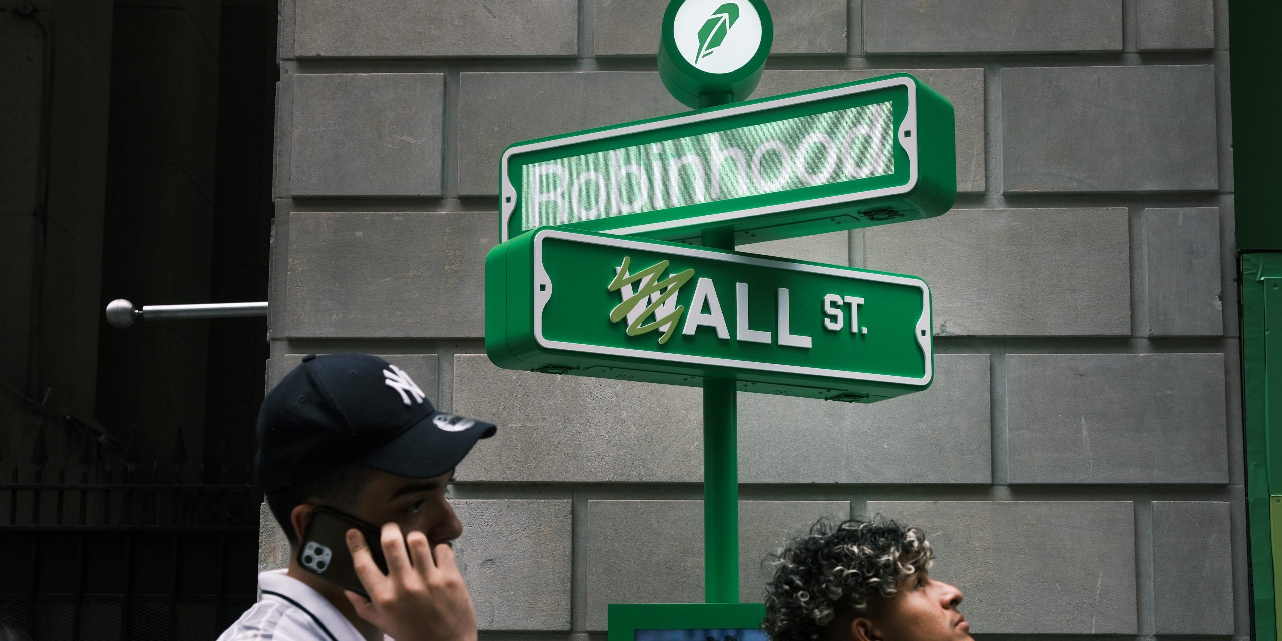 People wait in line for t-shirts at a pop-up kiosk for the online brokerage Robinhood along Wall Street after the company went public with an IPO earlier in the day on July 29, 2021 in New York City.