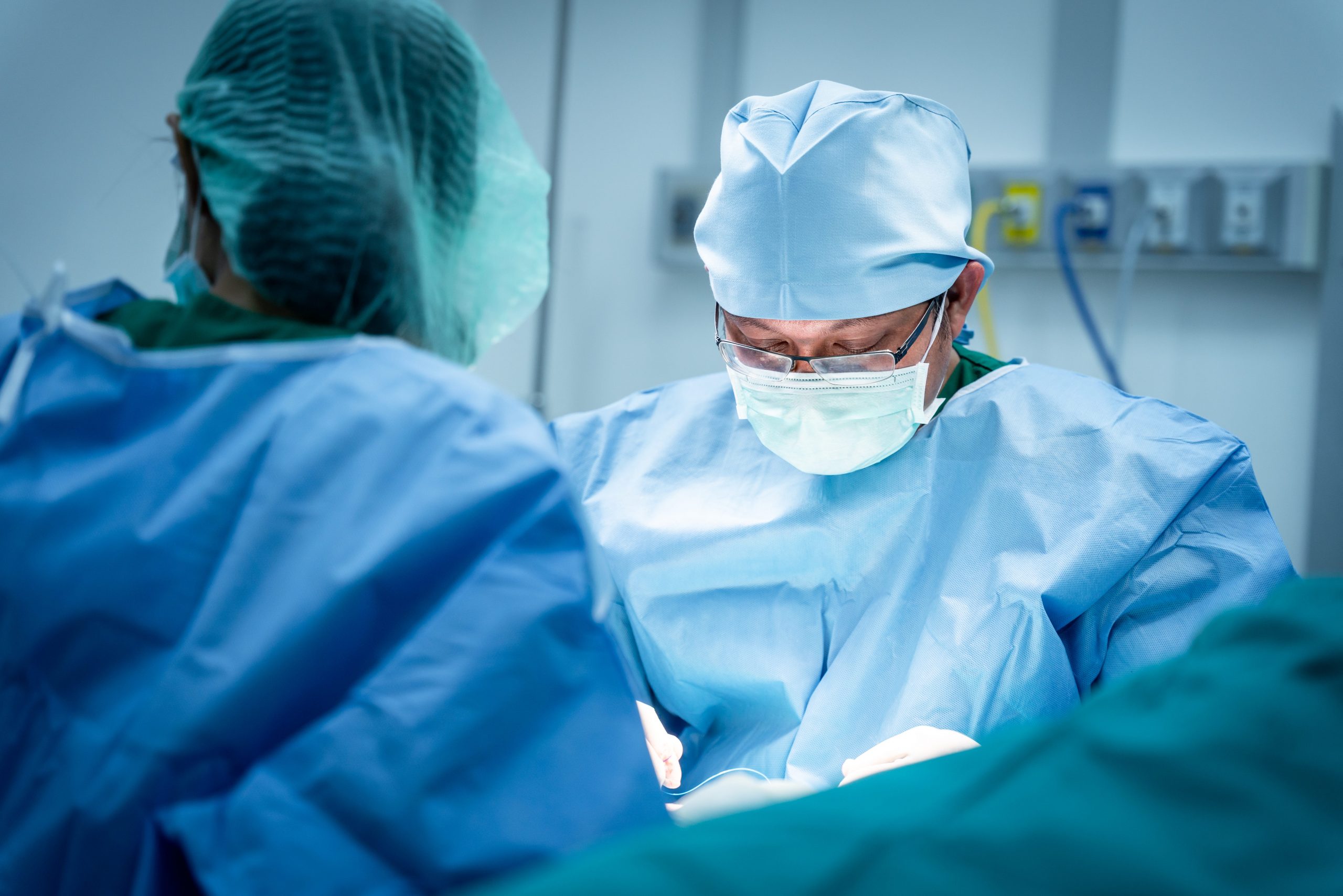 Close-up of masked surgeons operating on a patient