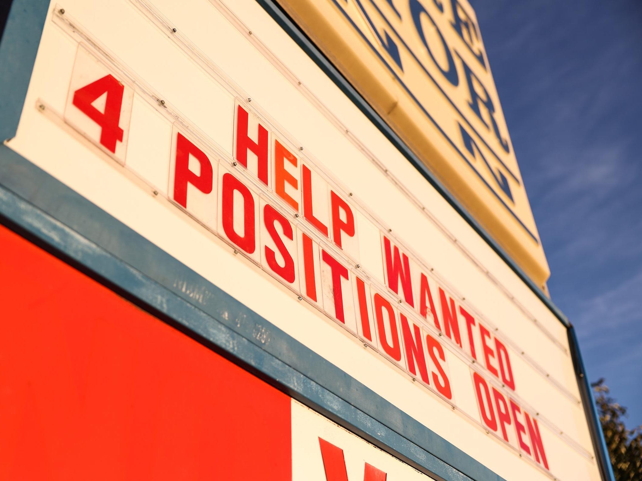 Now hiring sign outside restaurant saying 4 positions open