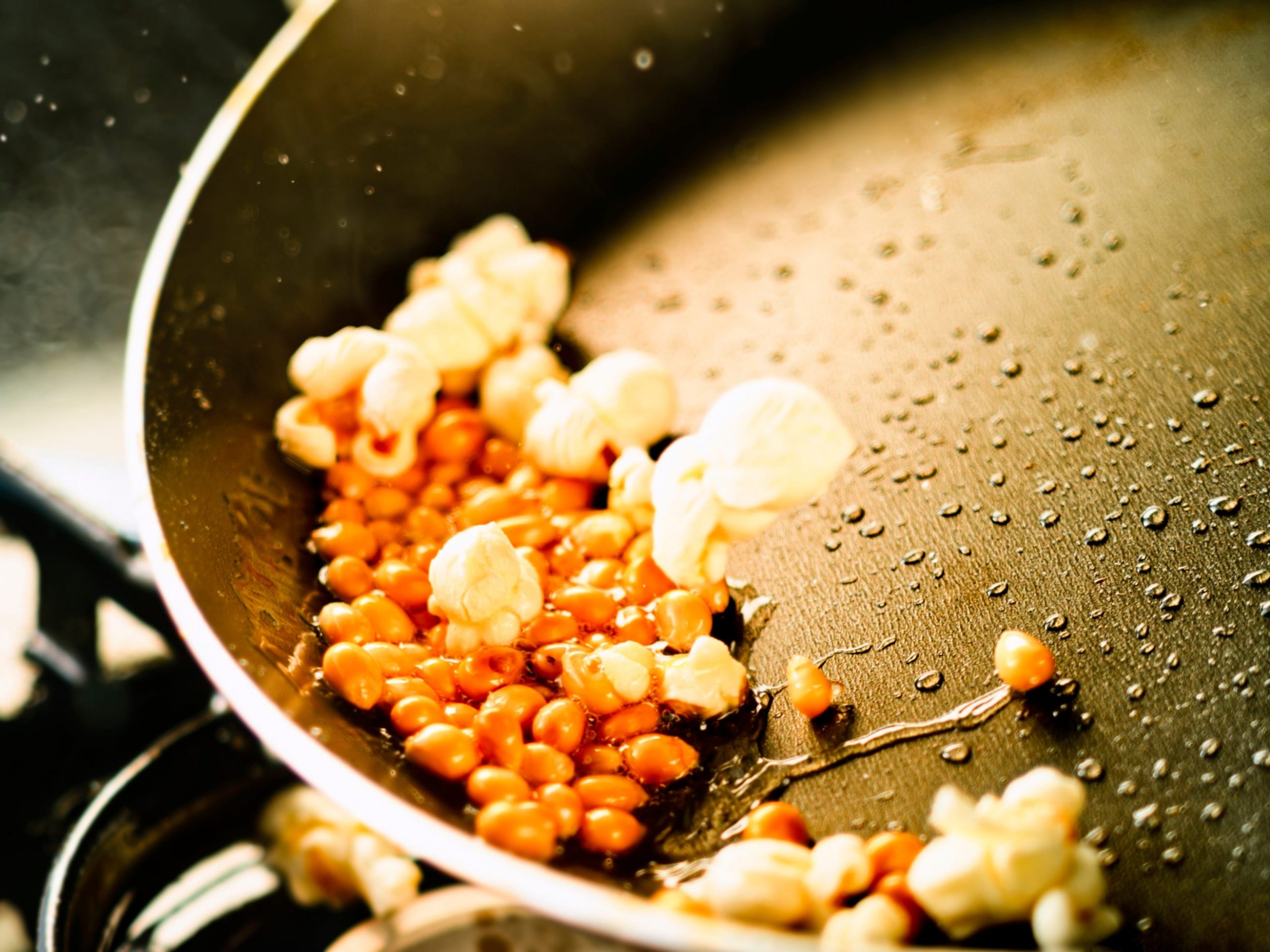 A pan with popped and unpopped corn kernels in it