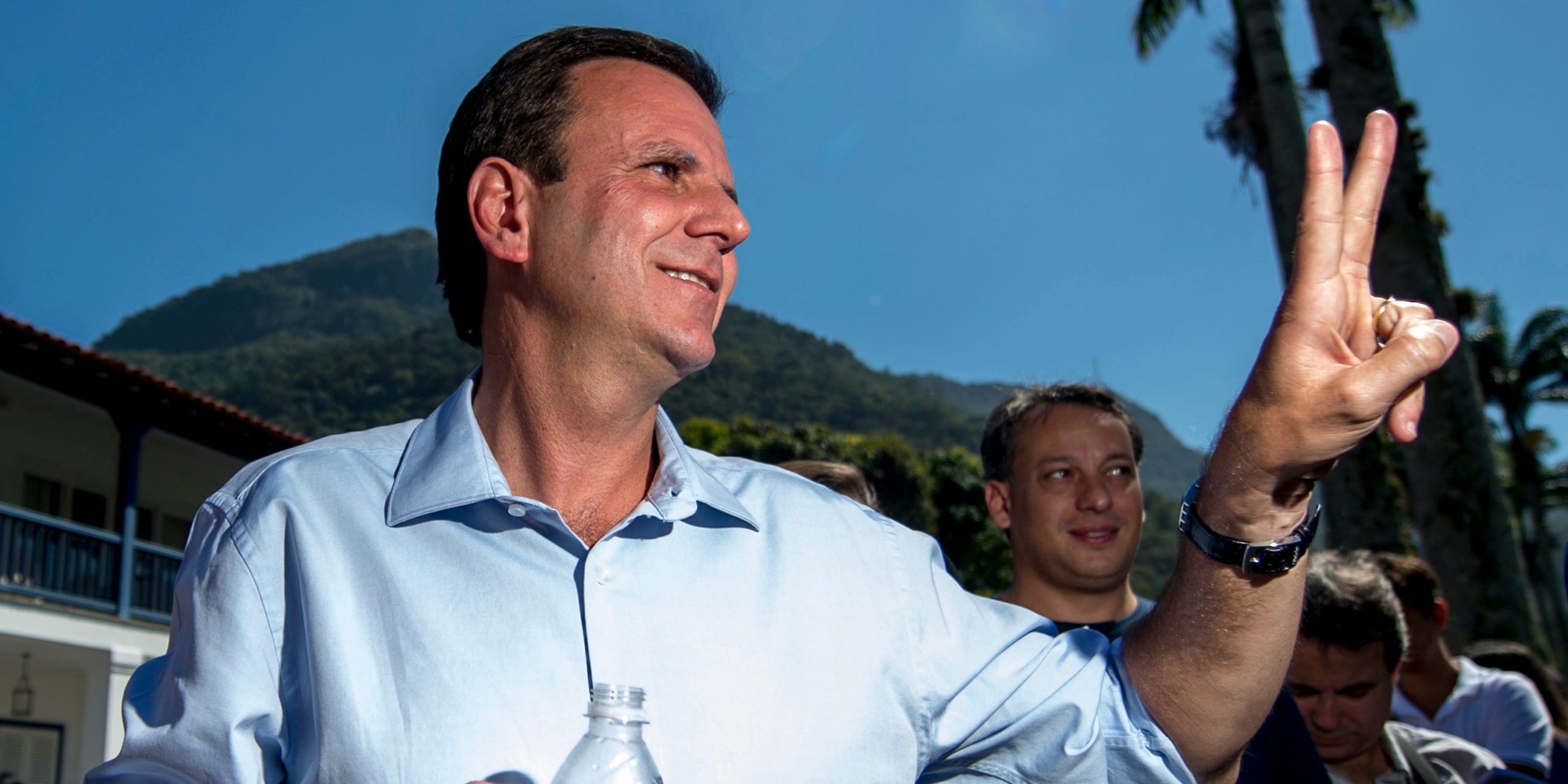 Rio de Janeiro's Mayor Eduardo Paes holds up the peace sign during a reelection campaign stop.