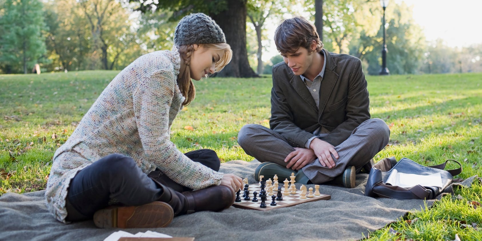 A couple plays chess in the park.