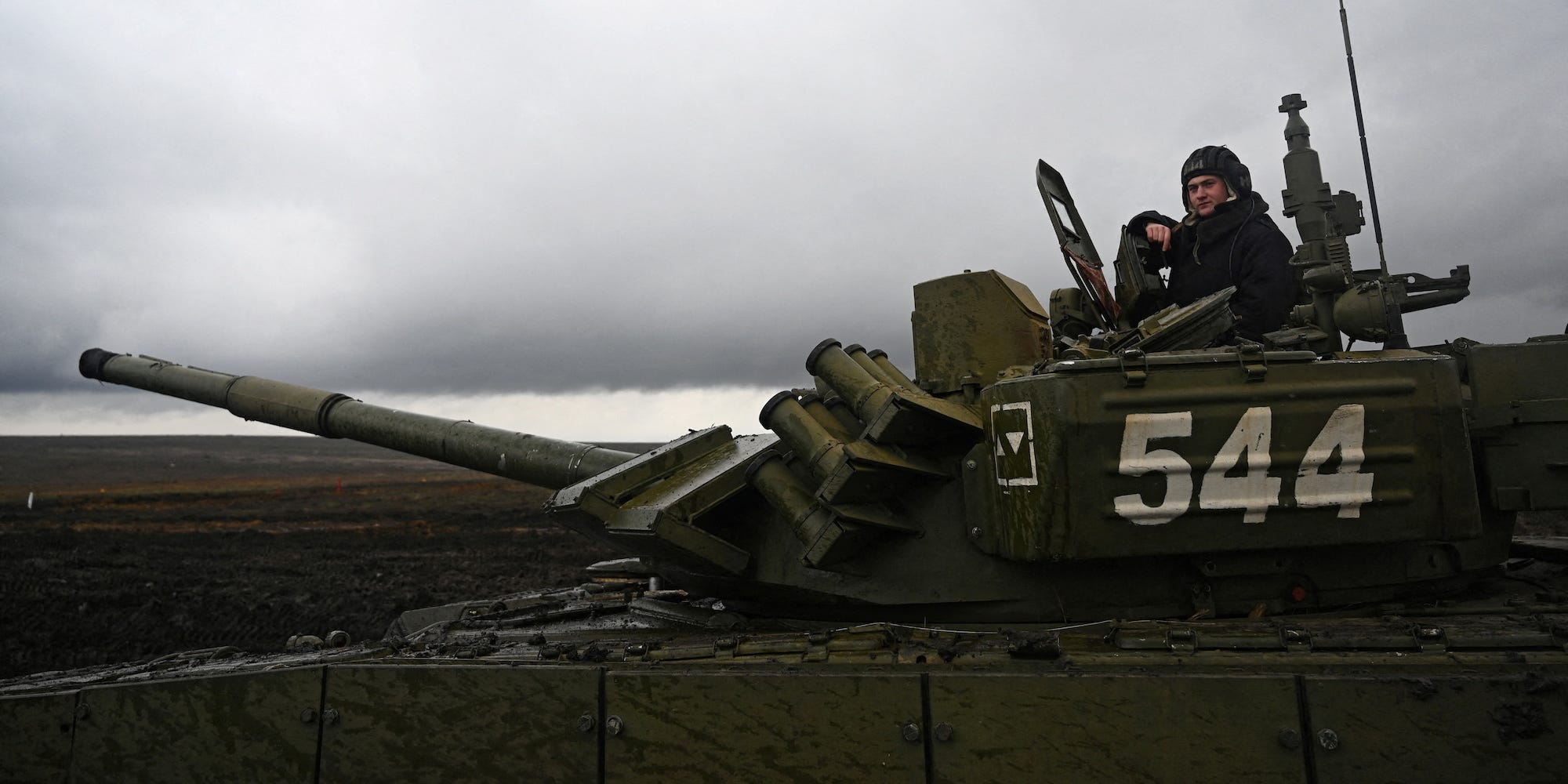 A Russian service member peeking out of the top of a tank