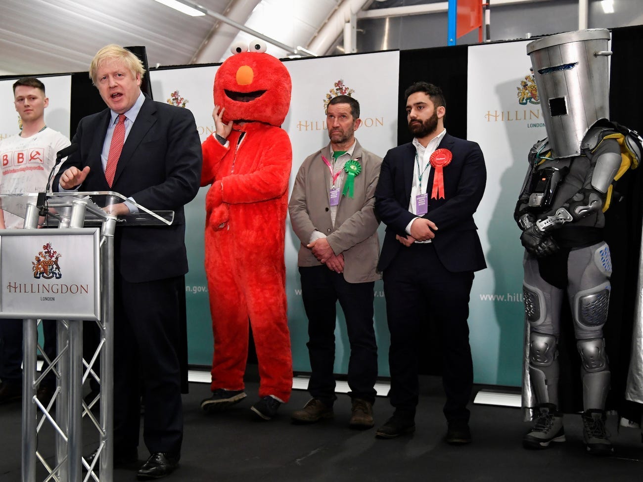 Boris Johnson stands next to Elmo and Lord Buckethead.