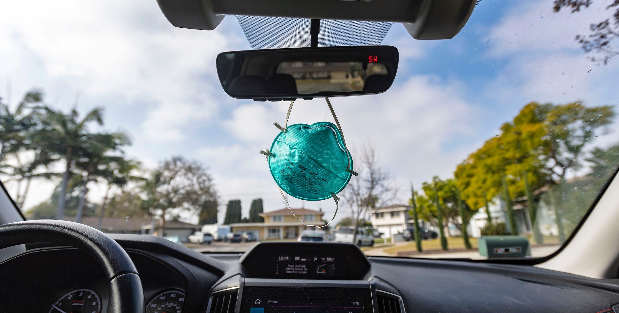 surgical mask dangling from rearview mirror
