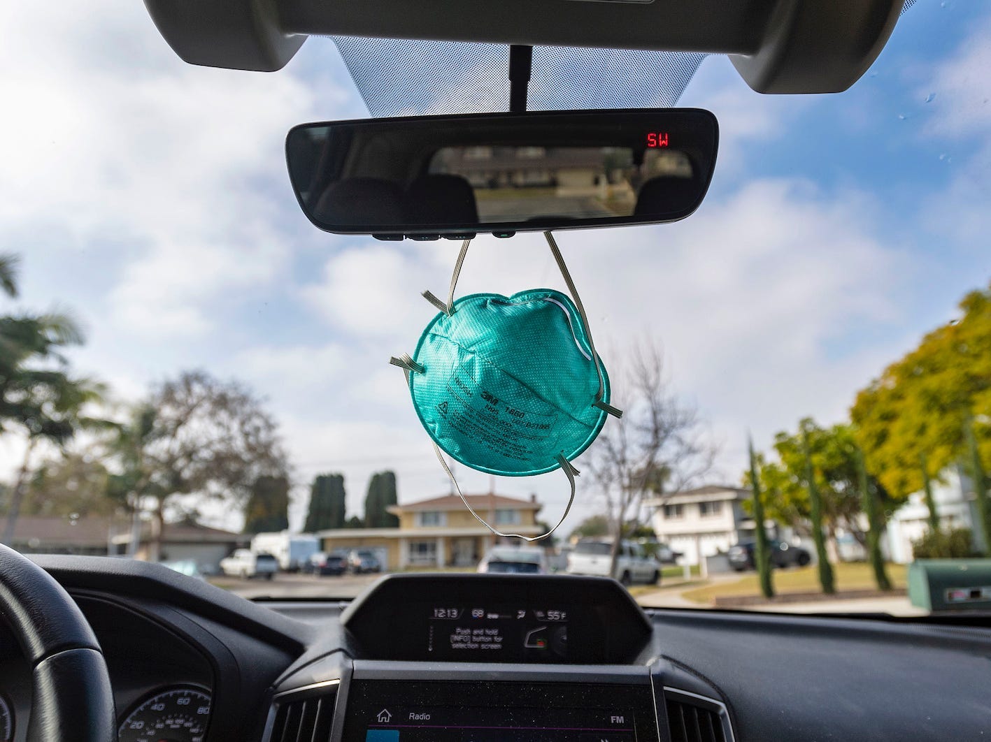 surgical mask dangling from rearview mirror