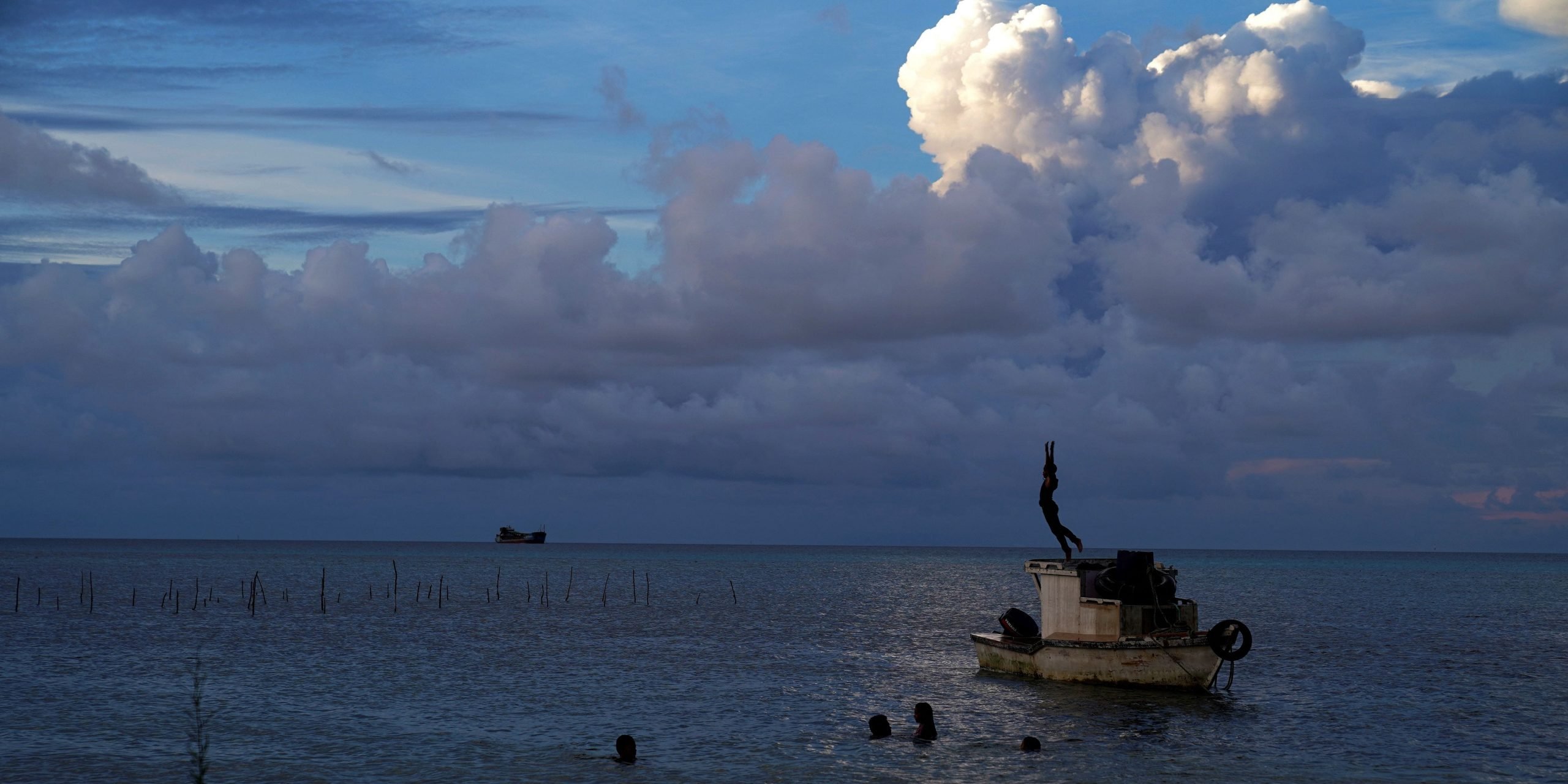 This picture taken on December 21, 2021 shows white gaseous clouds rising from the Hunga Ha'apai eruption seen from the Patangata coastline near Tongan capital Nuku'alofa. - A huge dust cloud spewed out when a volcano erupted in Tonga this week could result in showers of acid rain across the Pacific kingdom, emergency authorities have warned.