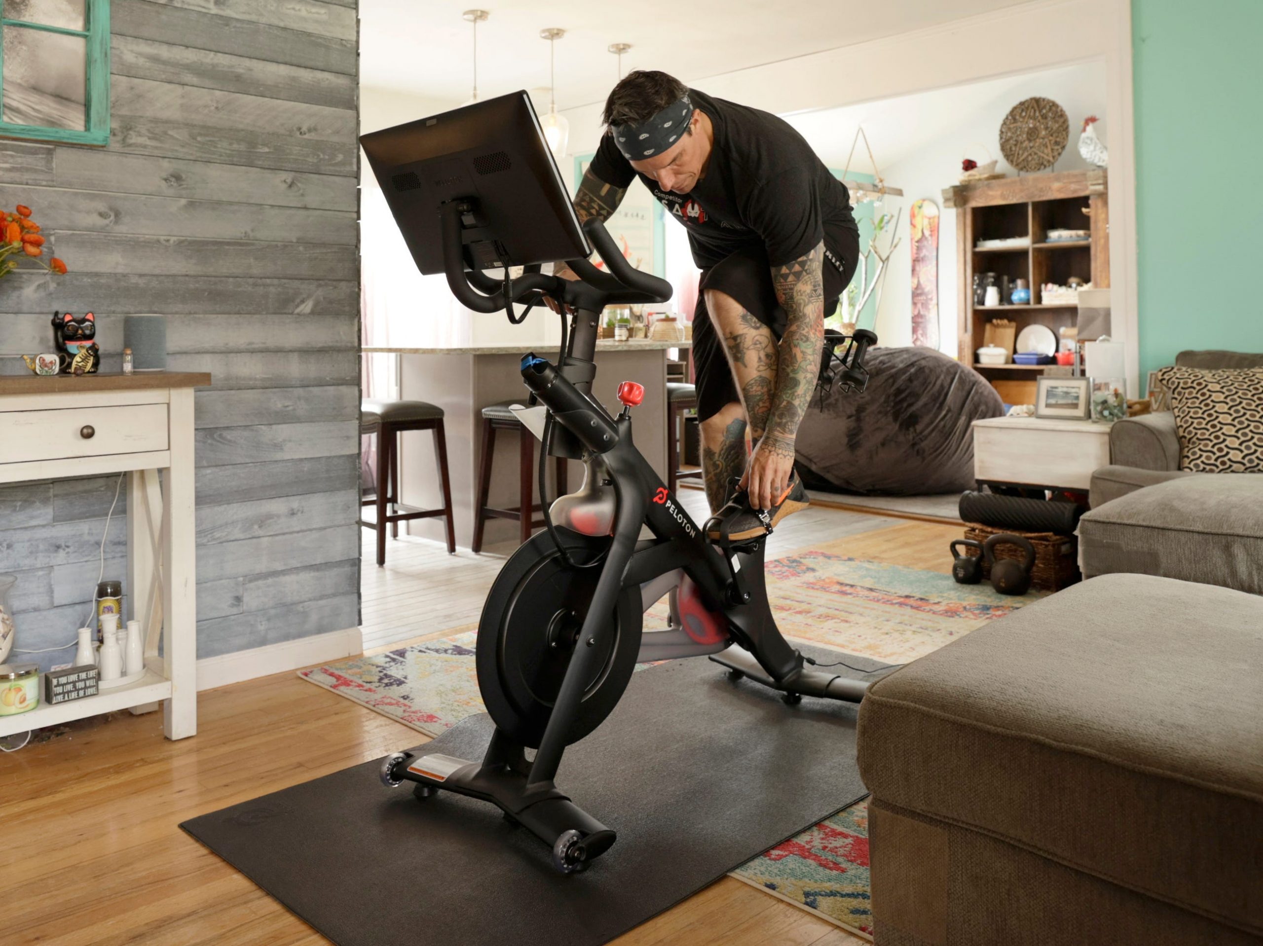 A man riding a Peloton bike in his living room.