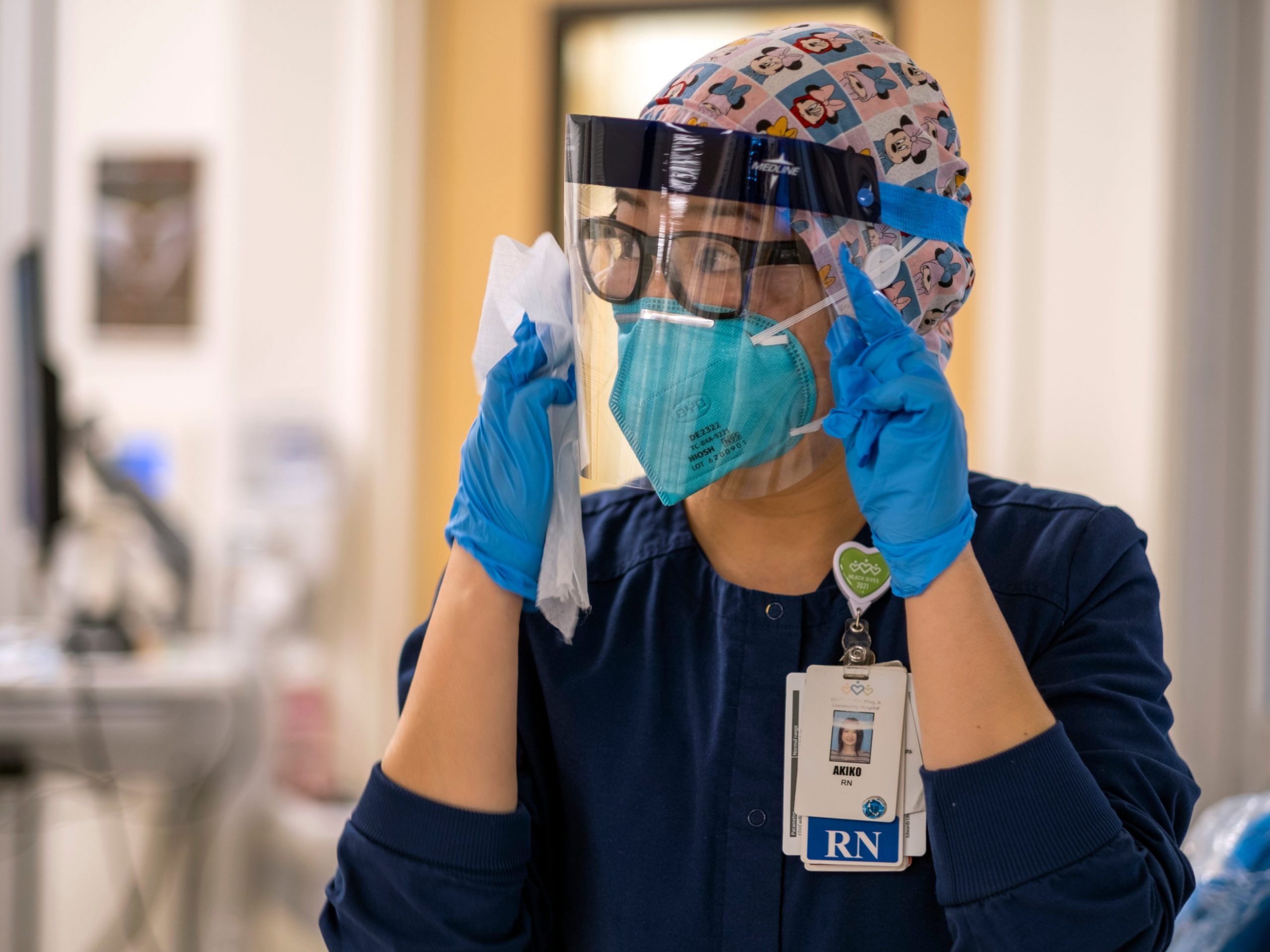 Registered nurse Akiko Gordon looks around the ICU while wearing a face shield, N95 mask, and scrubs.