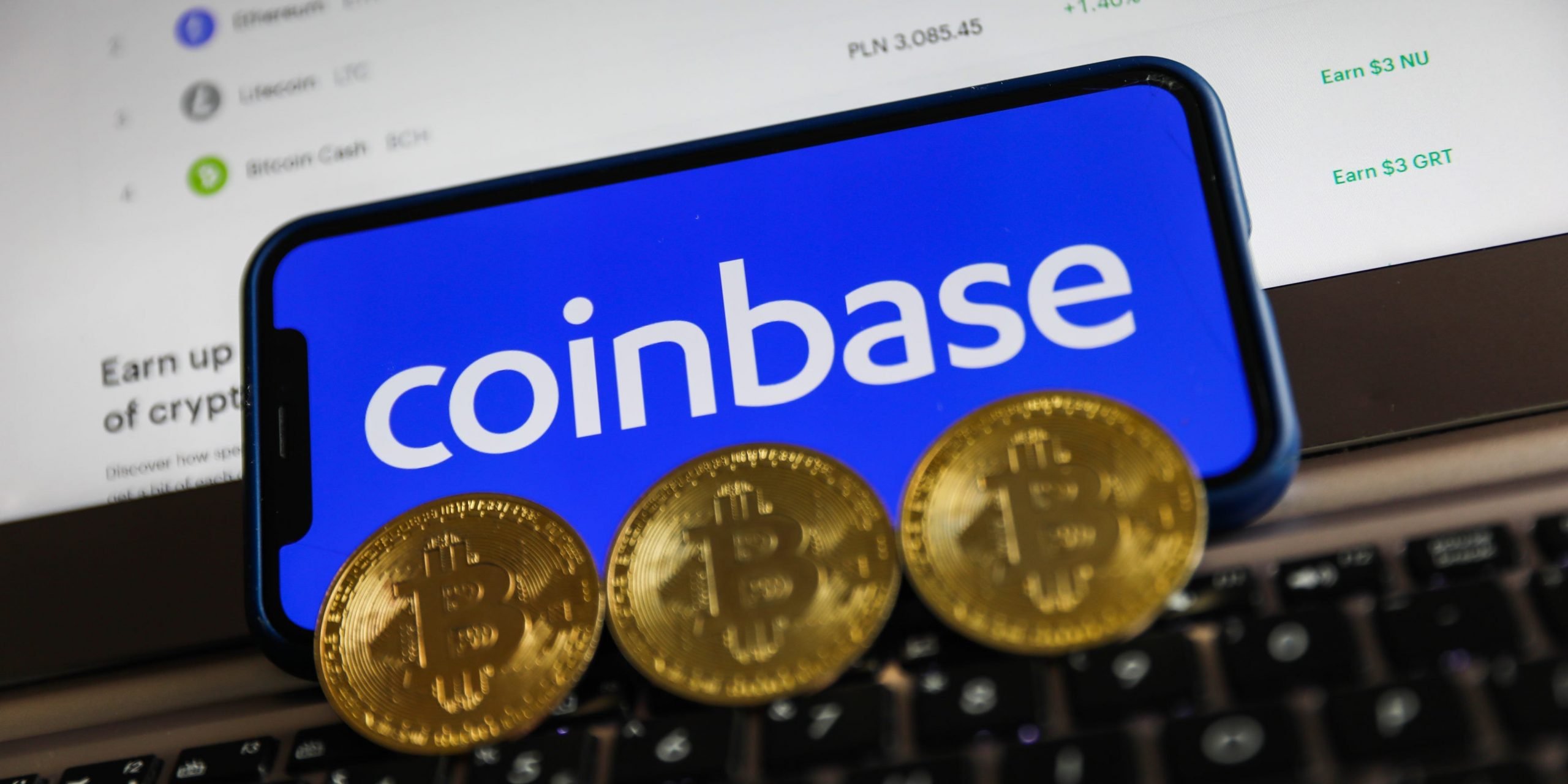 Coinbase logo displayed on a phone screen and representation of Bitcoin are seen in this illustration photo taken in Krakow, Poland on April 15, 2021