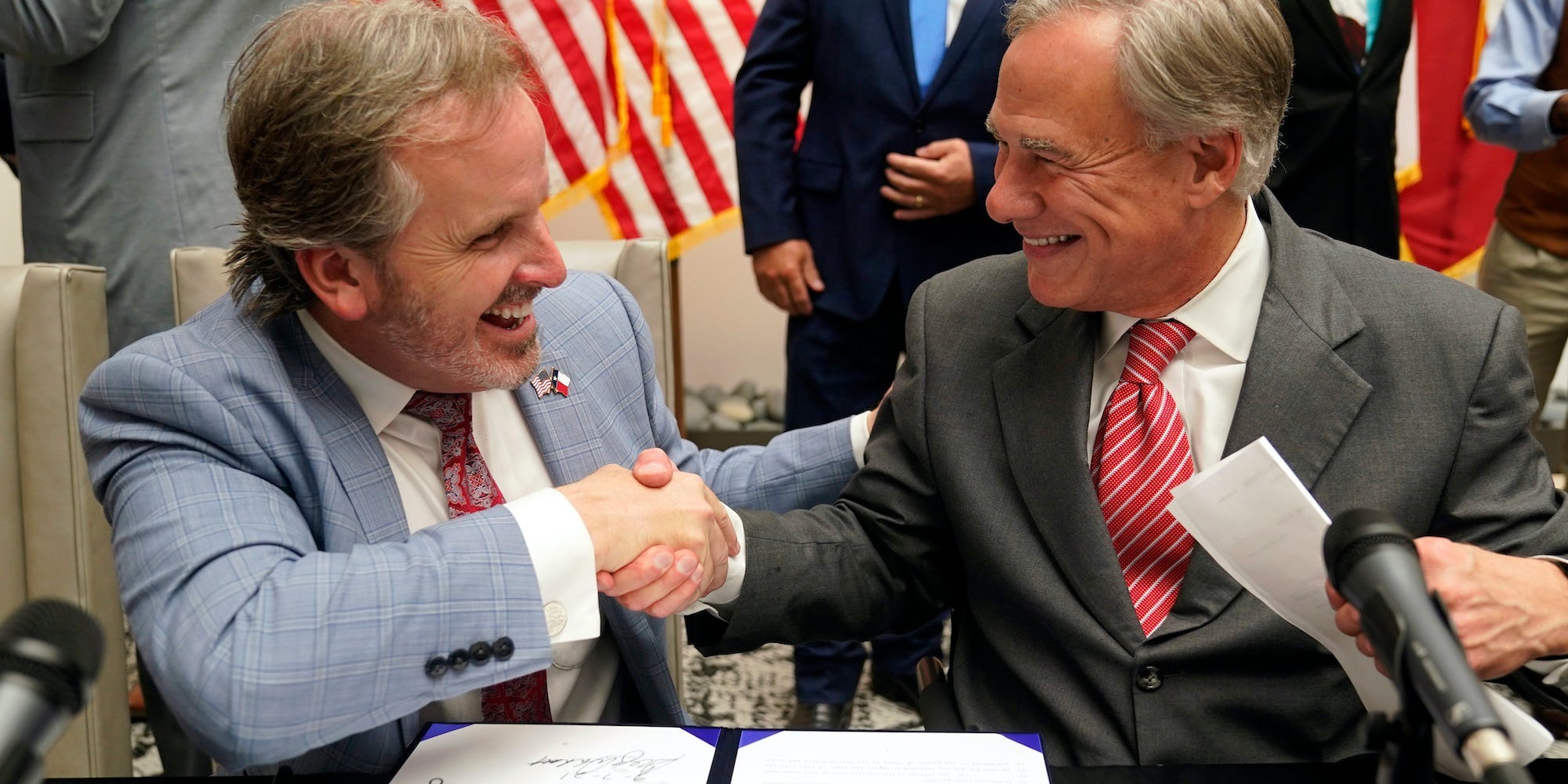 Texas Gov Greg Abbott and State Sen. Bryan Hughes, R-Mineola, shake hands after Abbott signed Senate Bill 1, also known as the election integrity bill, into law in Tyler, Texas, Tuesday, Sept. 7, 2021.