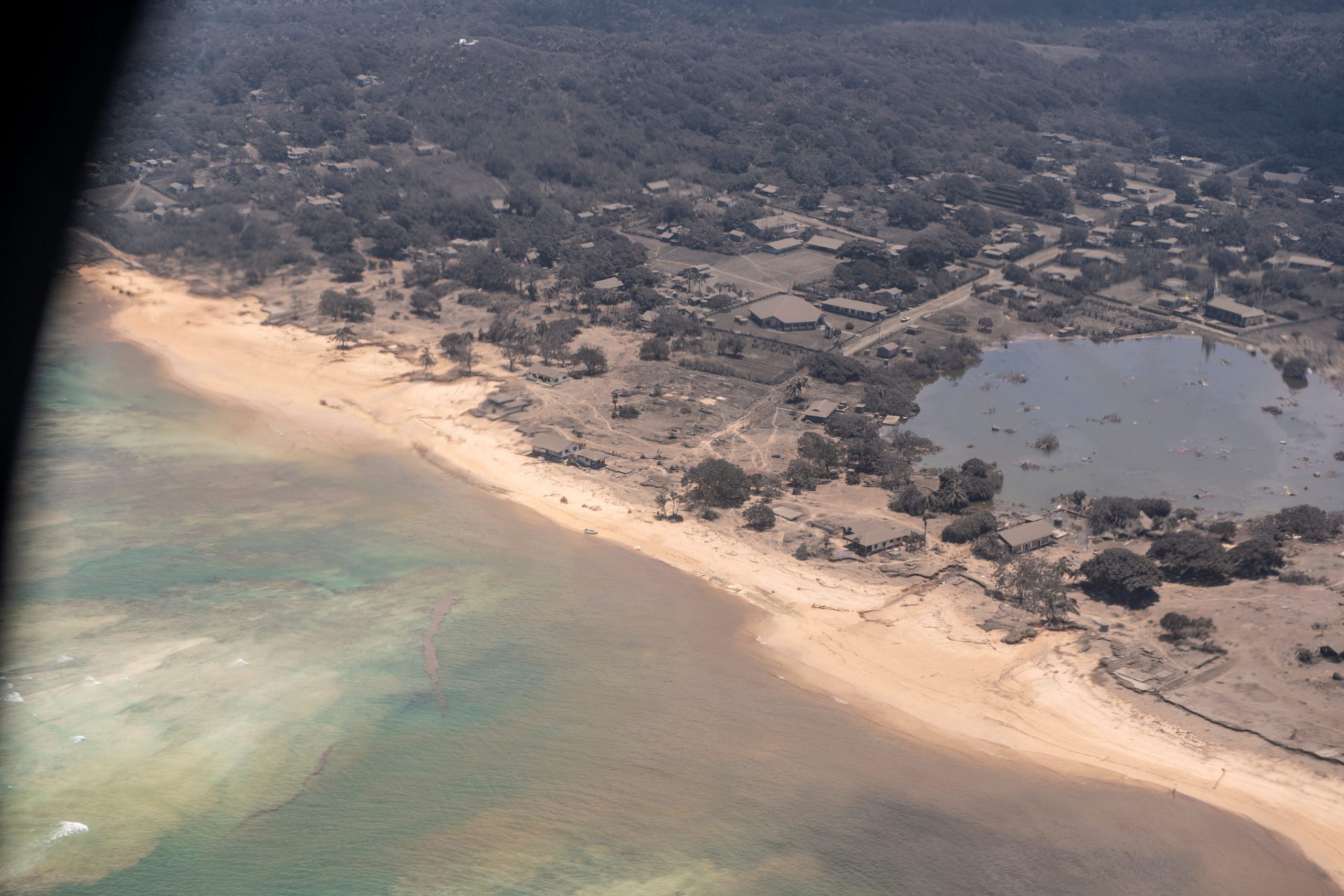 A view through the window of a New Zealand Defence Force P-3K2 Orion surveillance flight shows heavy ash fall over Nomuka in Tonga