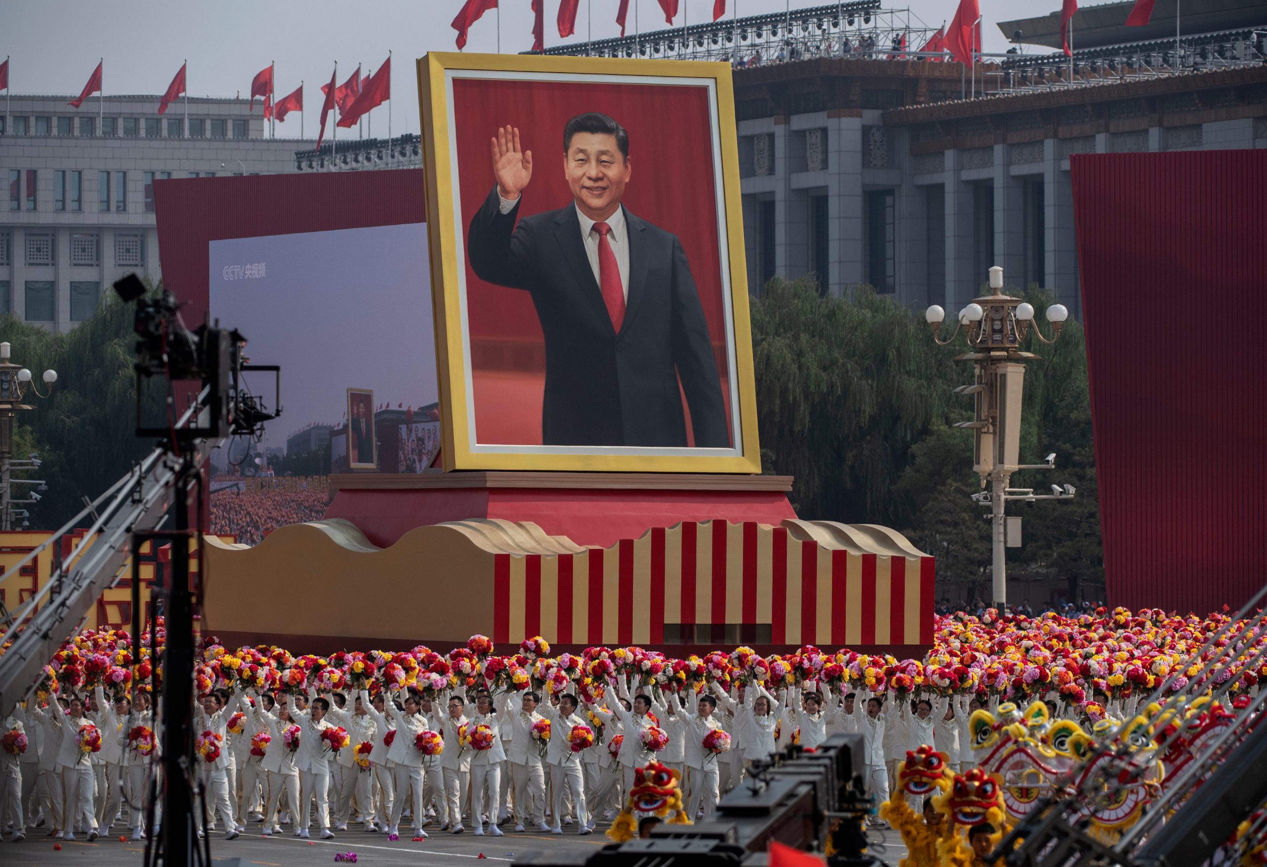 A giant photo of Xi Jinping is hoisted by a parade float on the CC
