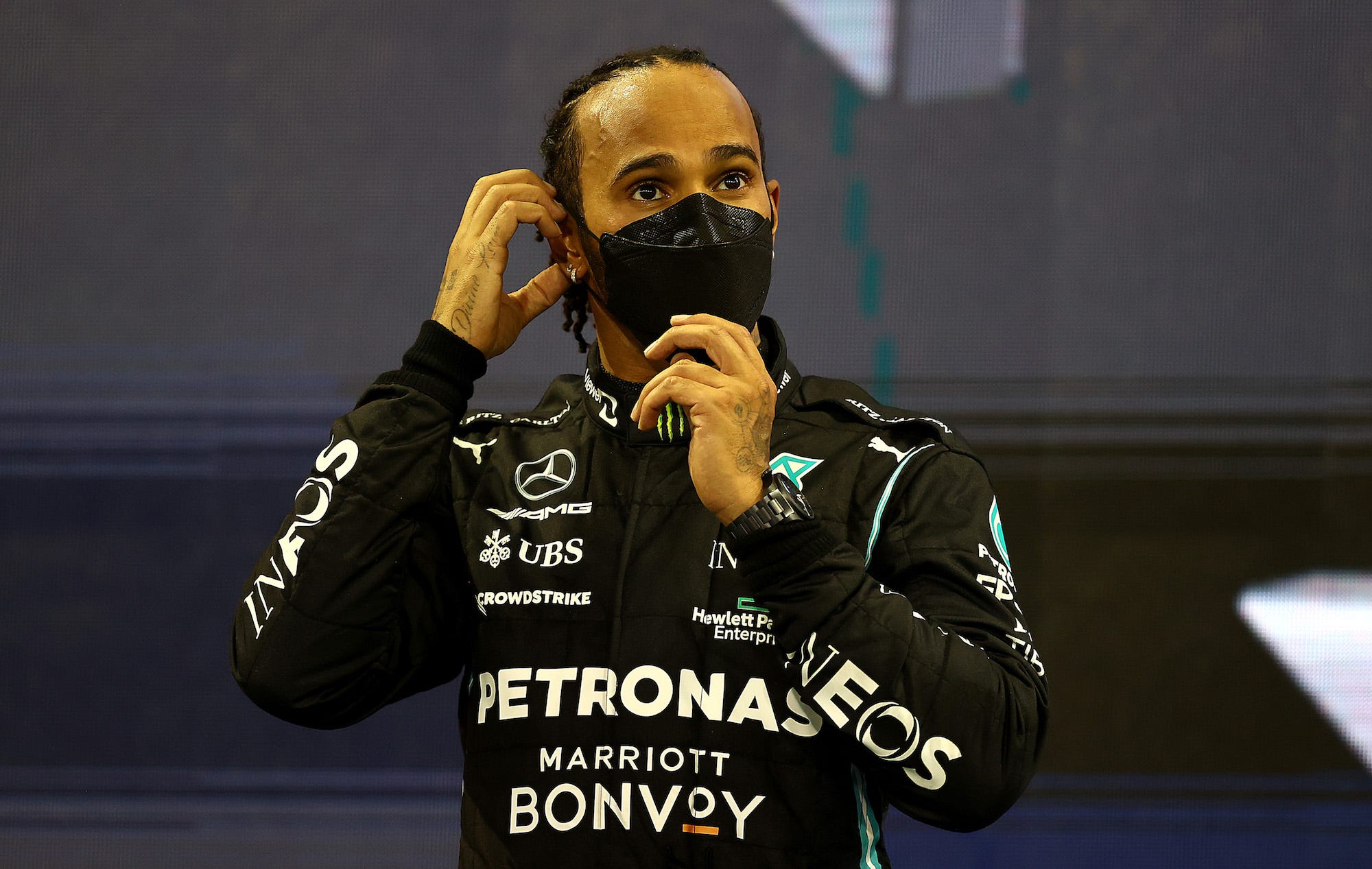 Second placed Lewis Hamilton of Great Britain and Mercedes GP looks on from the podium during the F1 Grand Prix of Abu Dhabi at Yas Marina Circuit