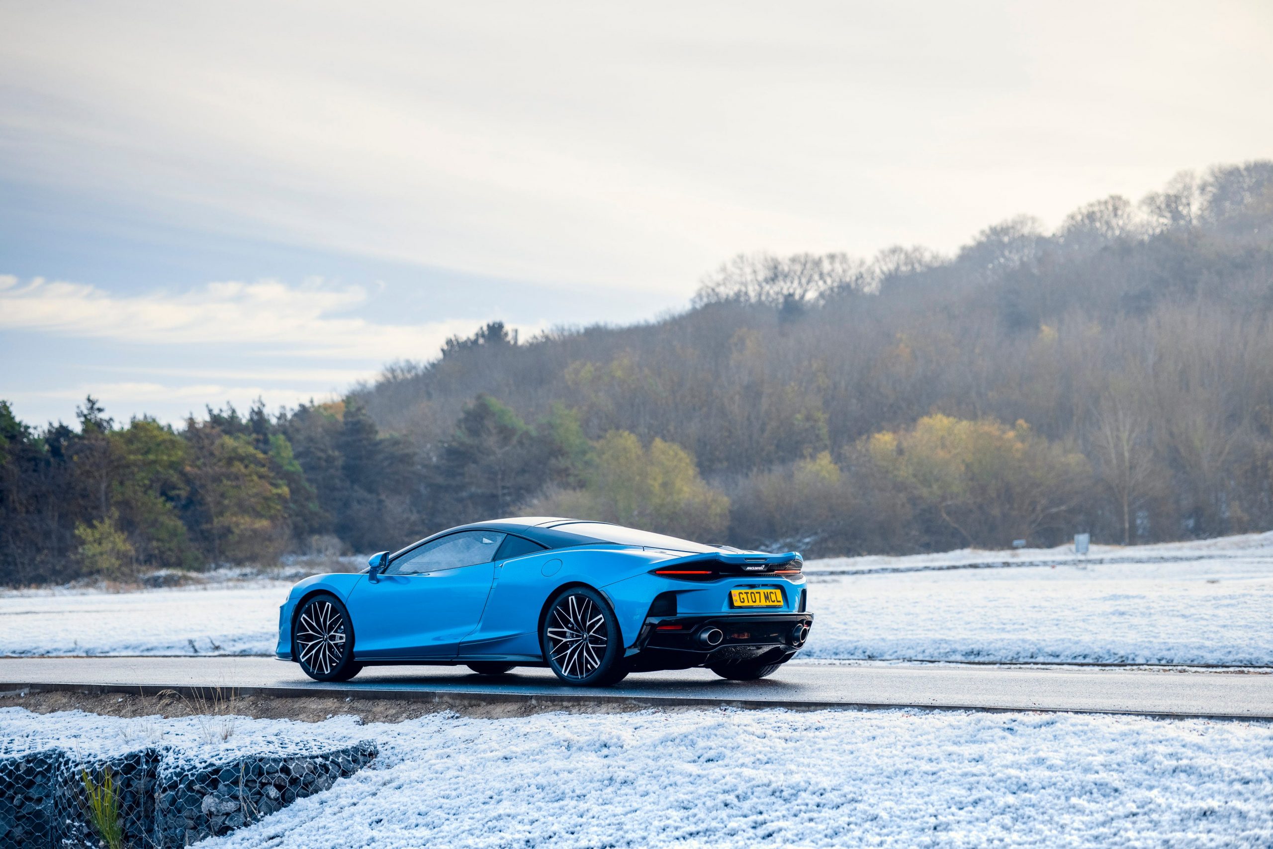 A blue McLaren GT in the snow.