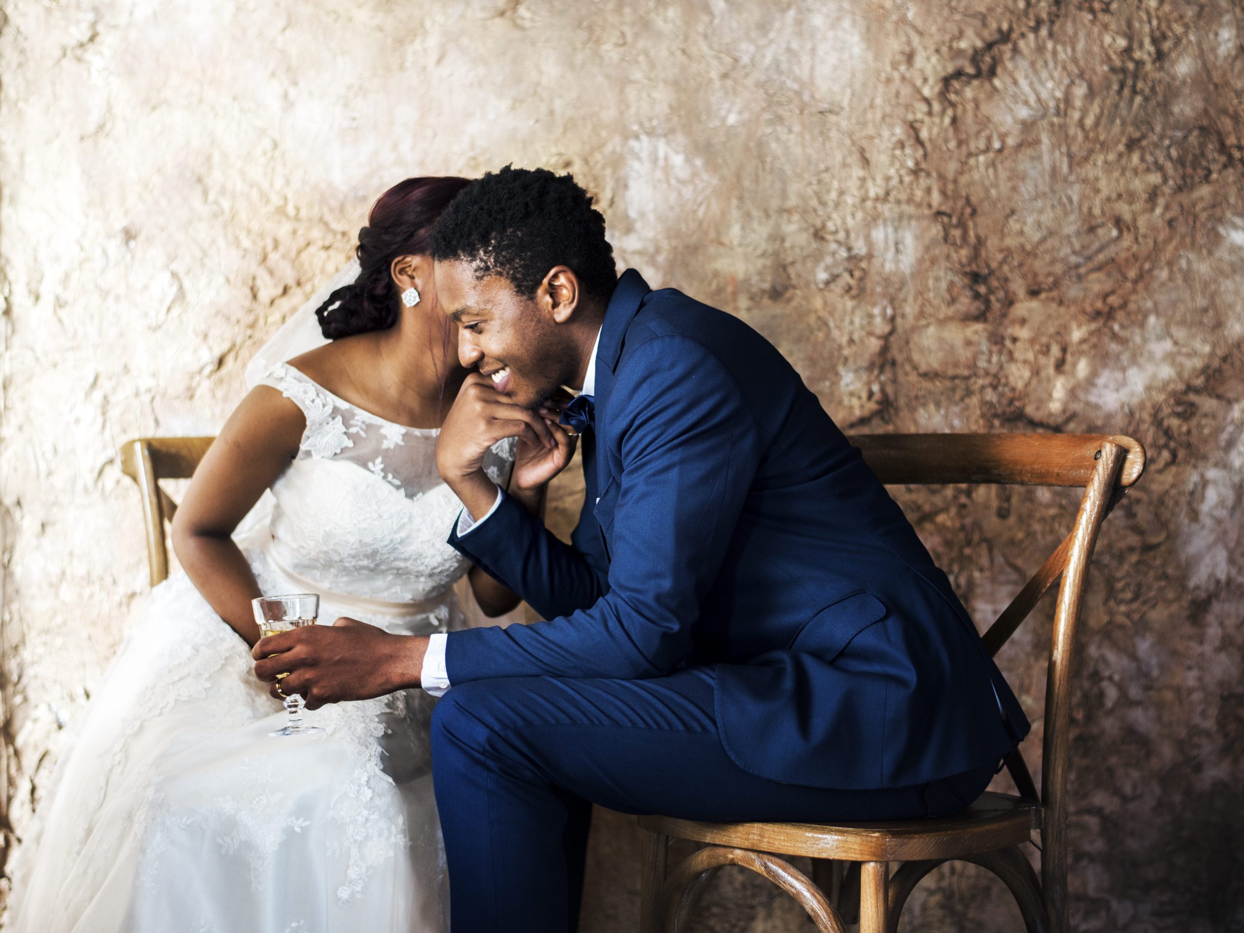 A couple embrace and talk on a chairs alone.