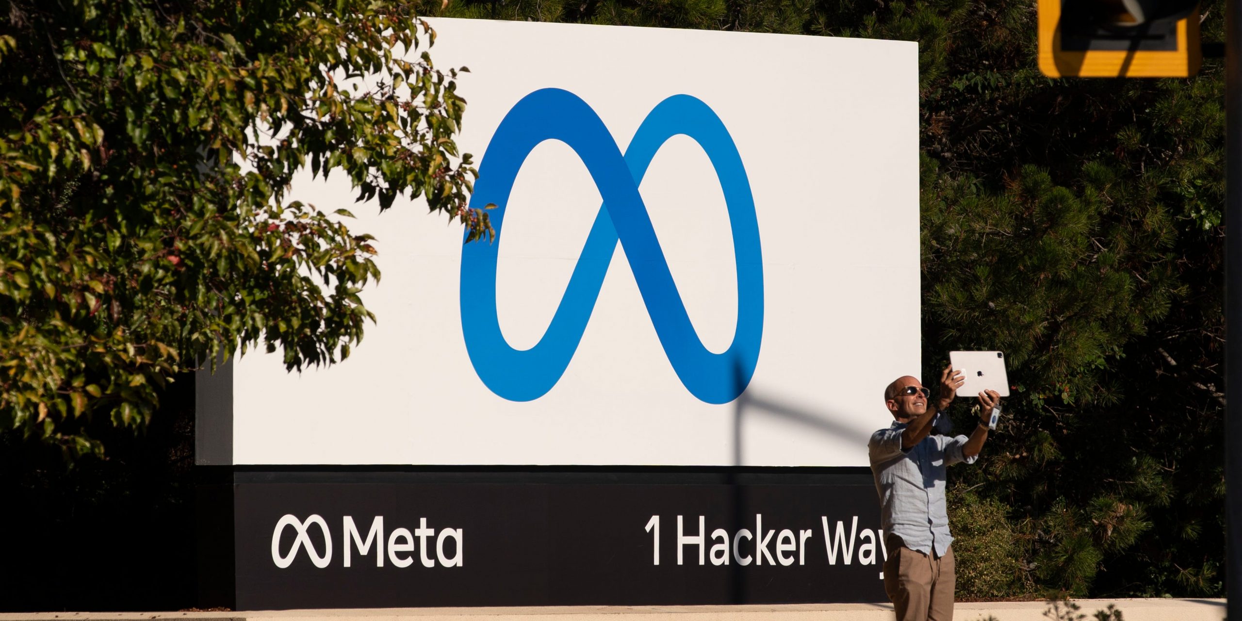A man takes pictures in front of a sign showing logo of Meta outside Facebook headquarters on October 28, 2021 in Menlo Park, California.