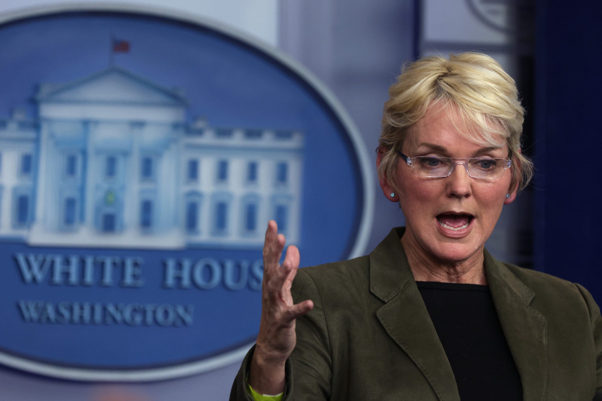 US Secretary of Energy Jennifer Granholm, her right hand raised to shoulder level, addresses reporters during a press conference in the White House briefing room.