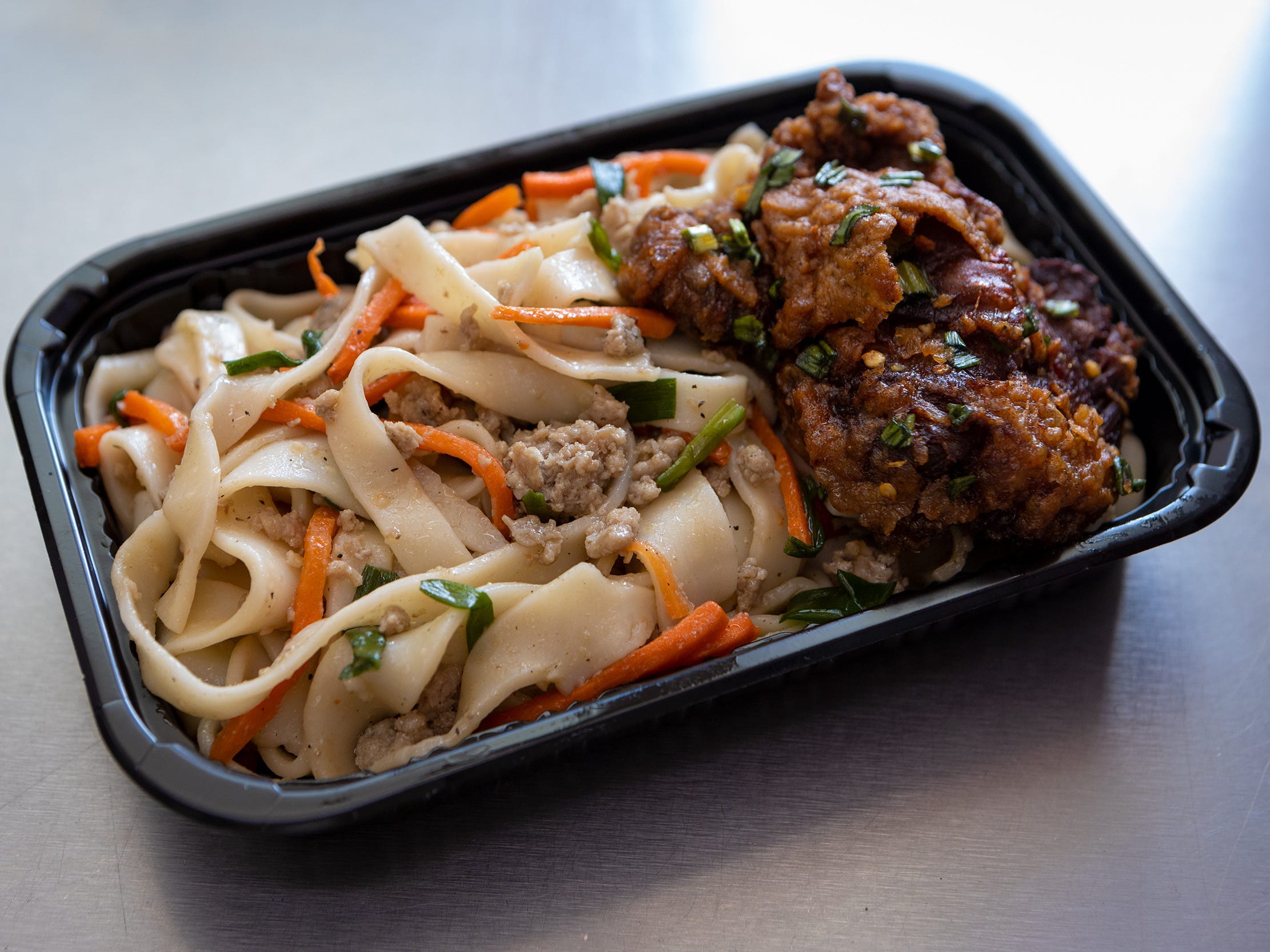 A bento dish with meat and noodles.