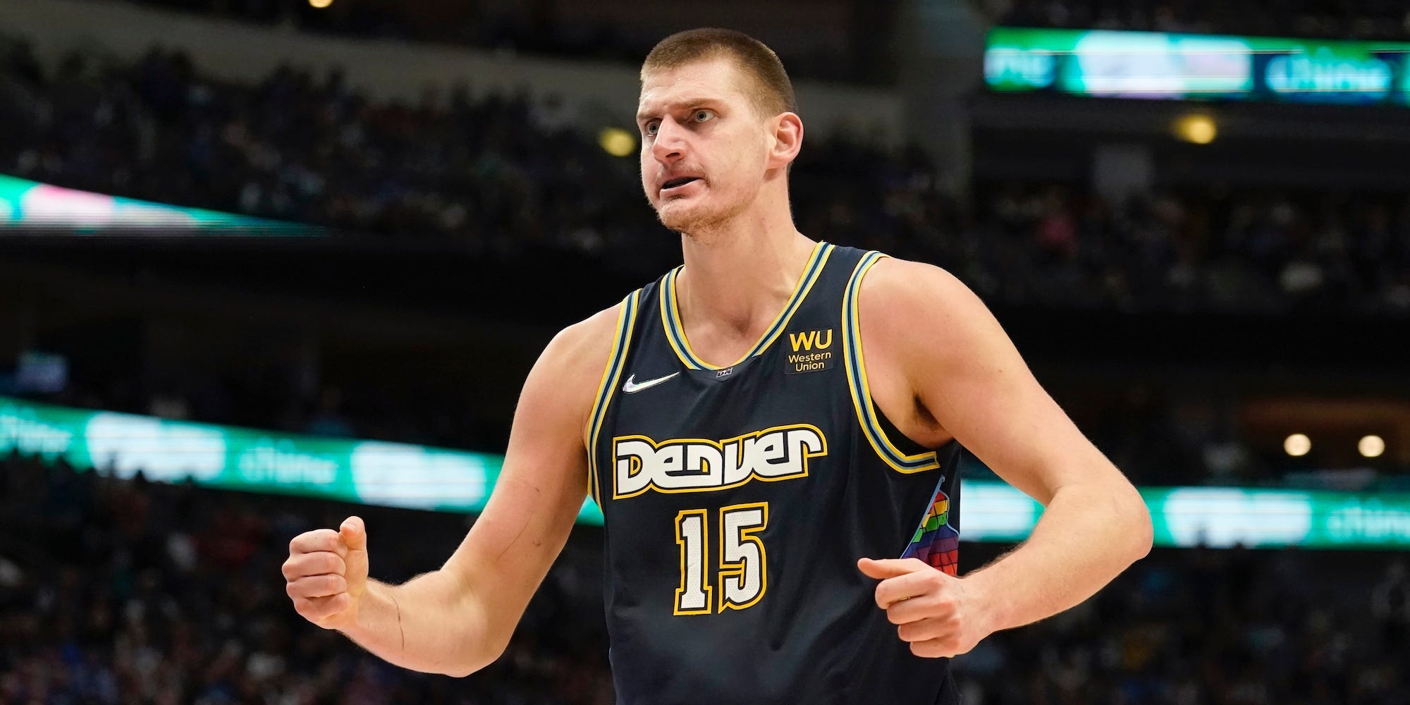 Nikola Jokic flexes and celebrates during a game.