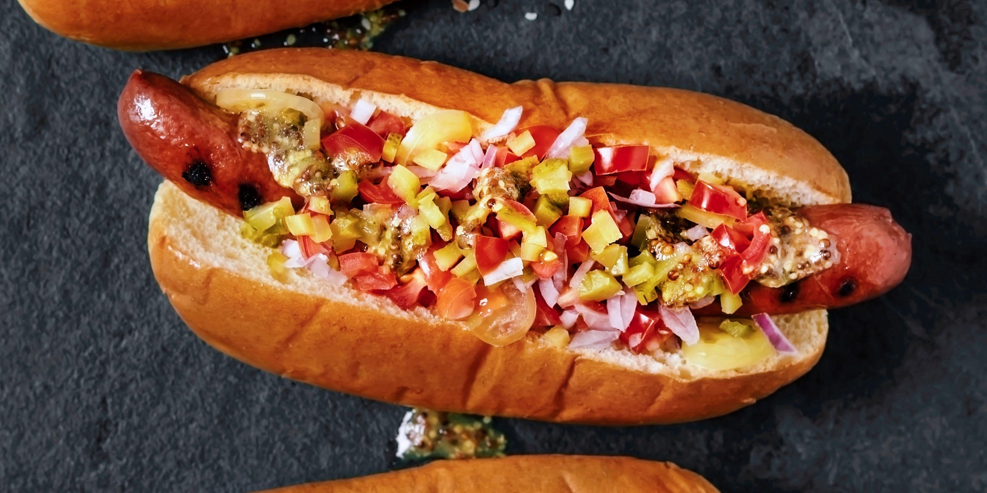 Loaded hot dog over a black background