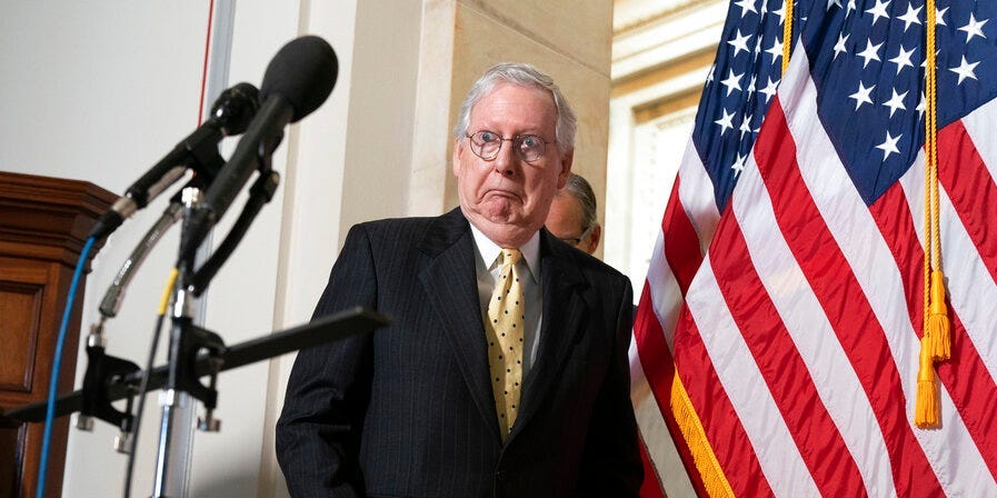 Senate Minority Leader Mitch McConnell of Ky., reacts after bumping into an American flag before speaking to the media, Tuesday, May 18, 2021, after a meeting of Senate Republicans on Capitol Hill in Washington.