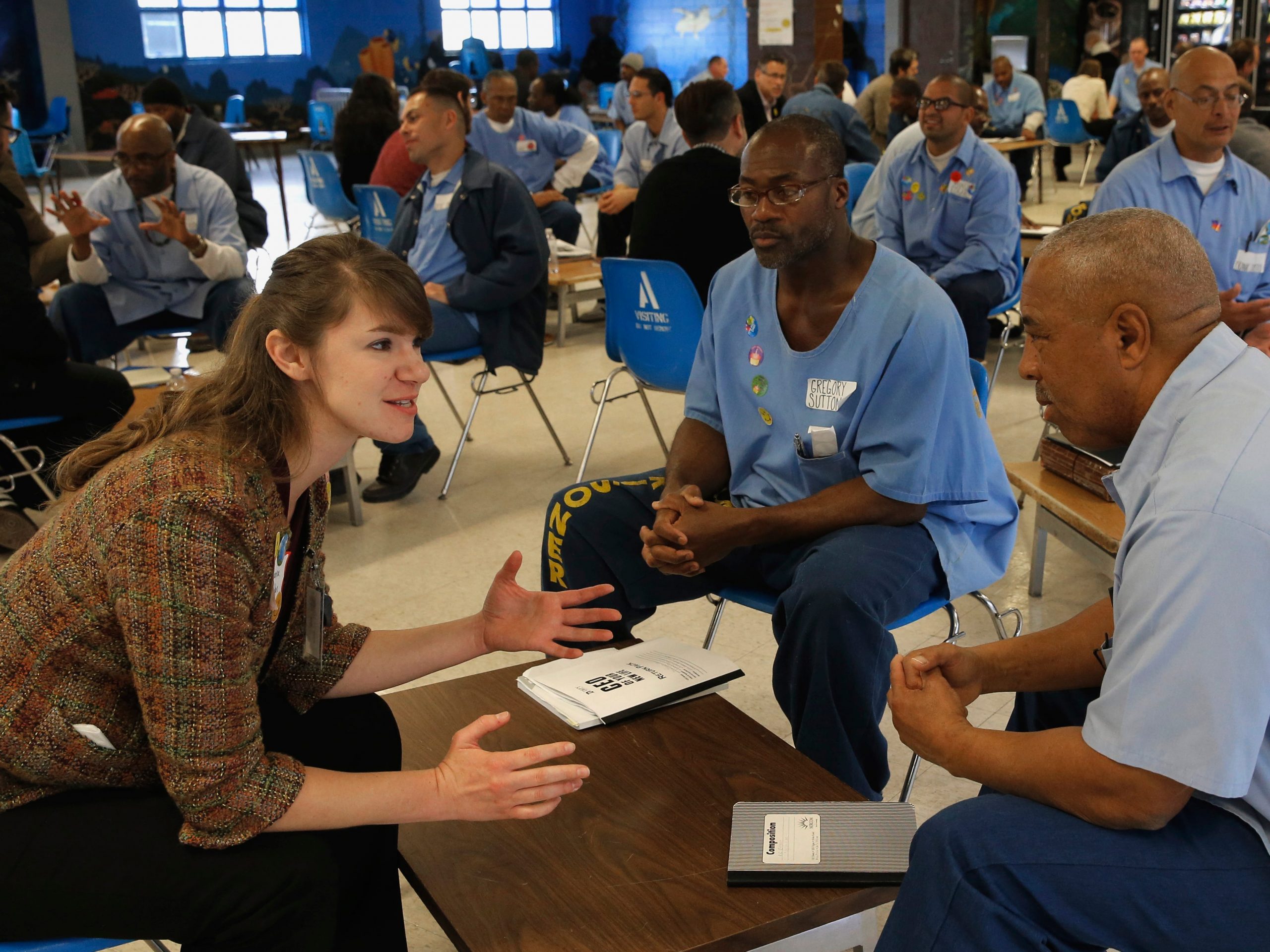 Volunteer Bianna Walden mentors students Gregory Sutton, (center) and Charles Commings, as Defy Ventures holds a business pitch competition for prisoners enrolled in the entrepreneurs in training program, at Solano State Prison in Vacaville, California in 2015.