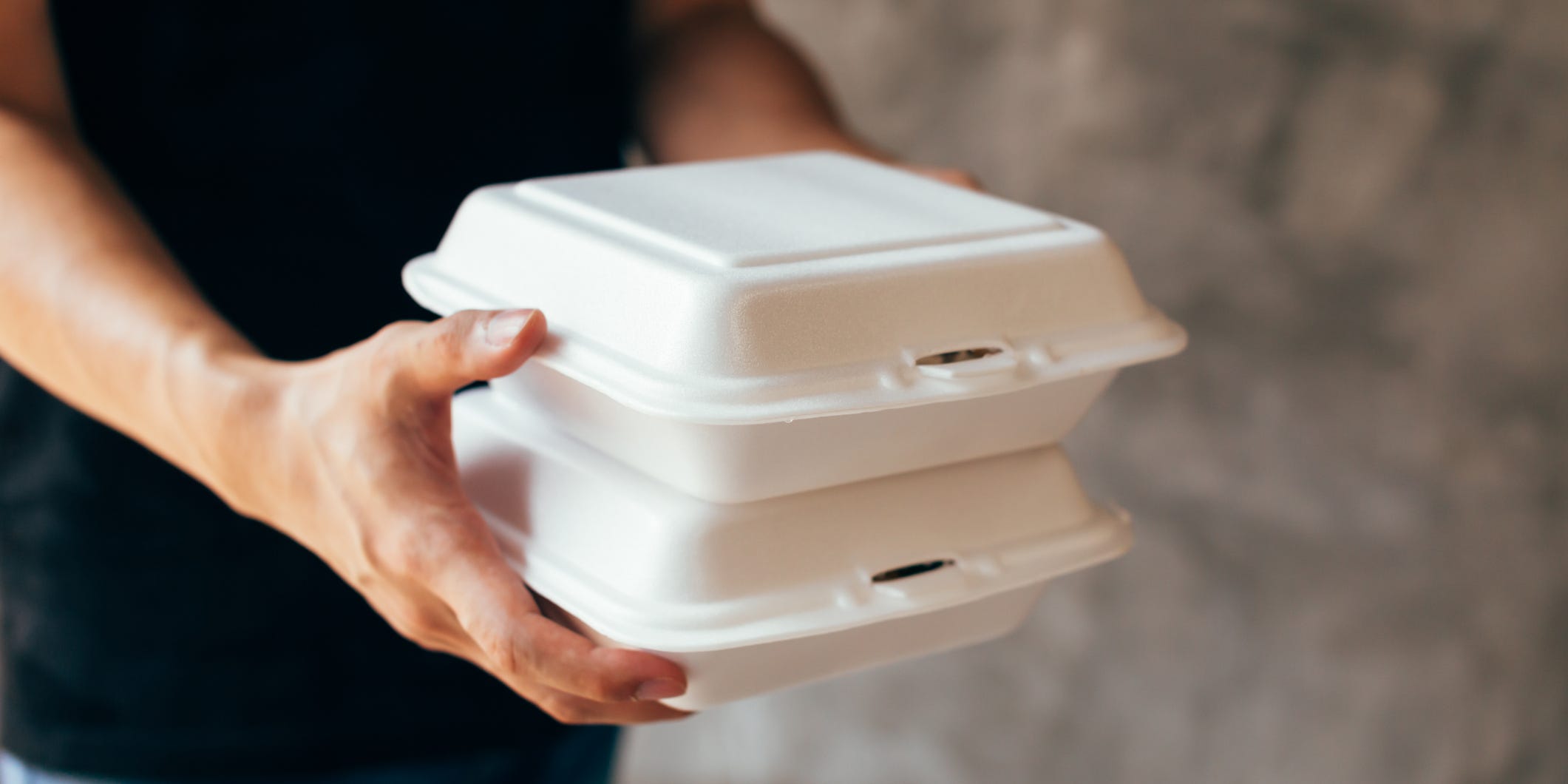 Person holding styrofoam food containers