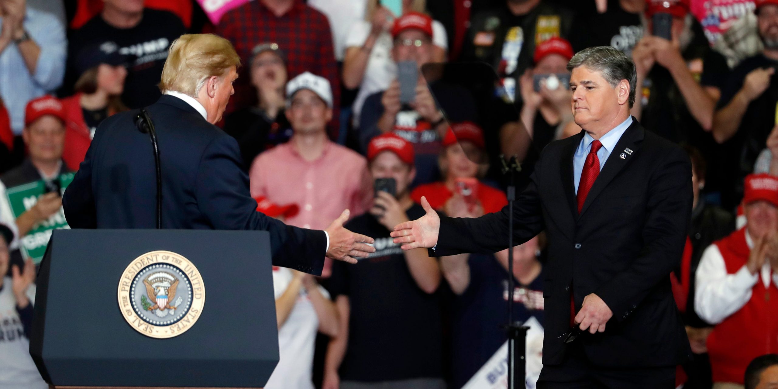 Former President Donald Trump shakes hands with Fox News Channel's Sean Hannity at a campaign rally on November 5, 2018, in Cape Girardeau, MO.