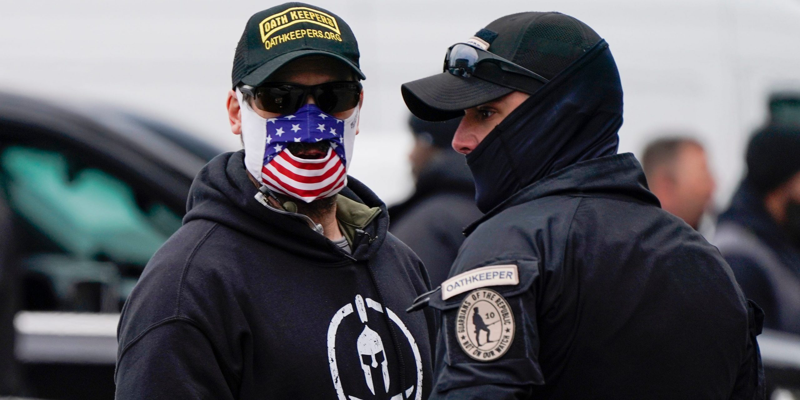 People wearing hats and patches indicating they are part of Oath Keepers attend a rally at Freedom Plaza Tuesday, Jan. 5, 2021, in Washington, in support of President Donald Trump.