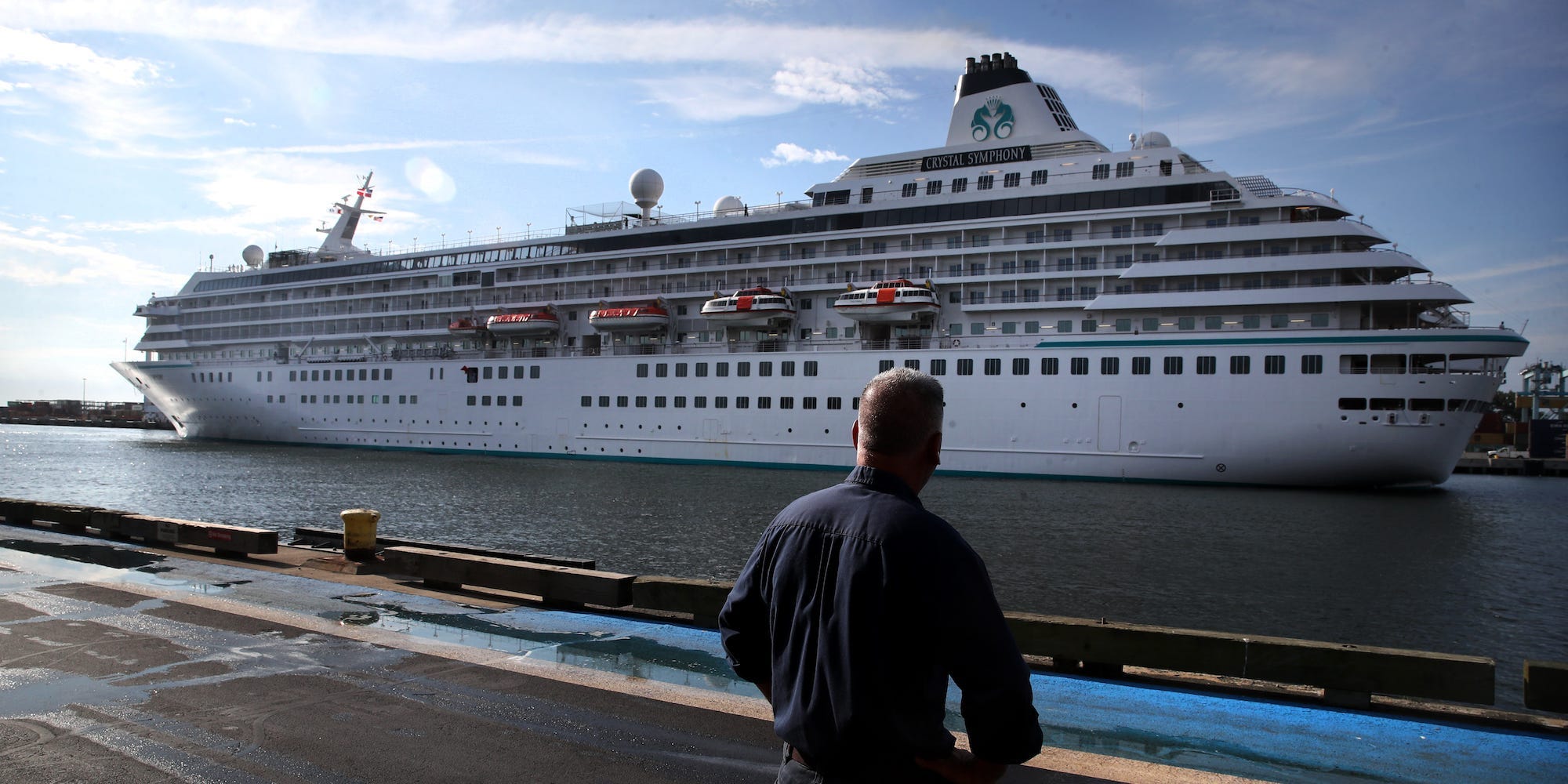 A pedestrian watches as the Crystal Symphony cruise ship arrives at Flynn Cruiseport in Boston, MA on August 18, 2021.