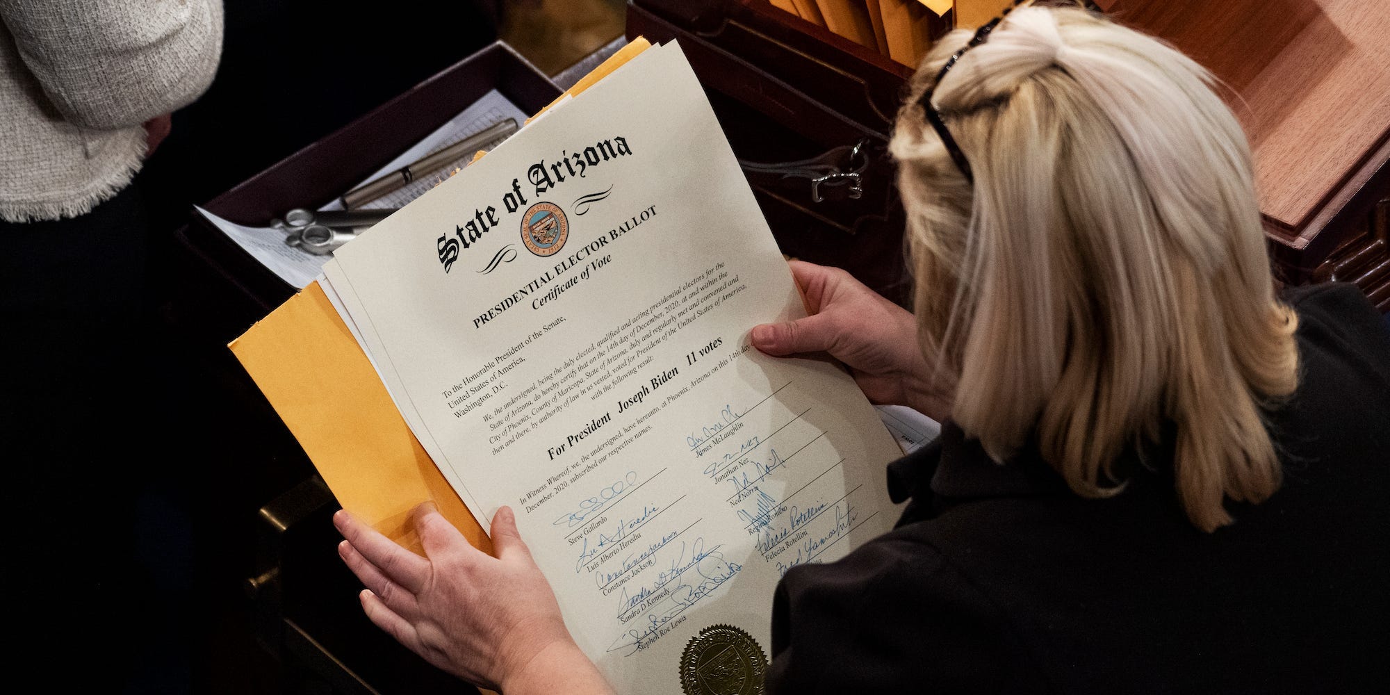 An aide holding Arizona's Electoral College ballot on the House floor on January 6.
