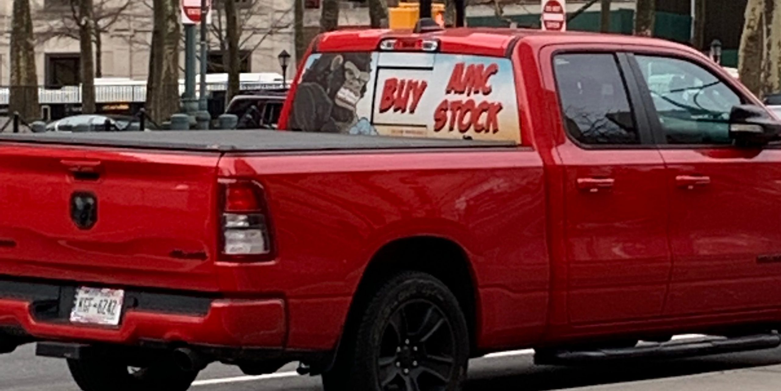 "Buy AMC stock" plastered on red truck driving around Tillary Street in Downtown Brooklyn