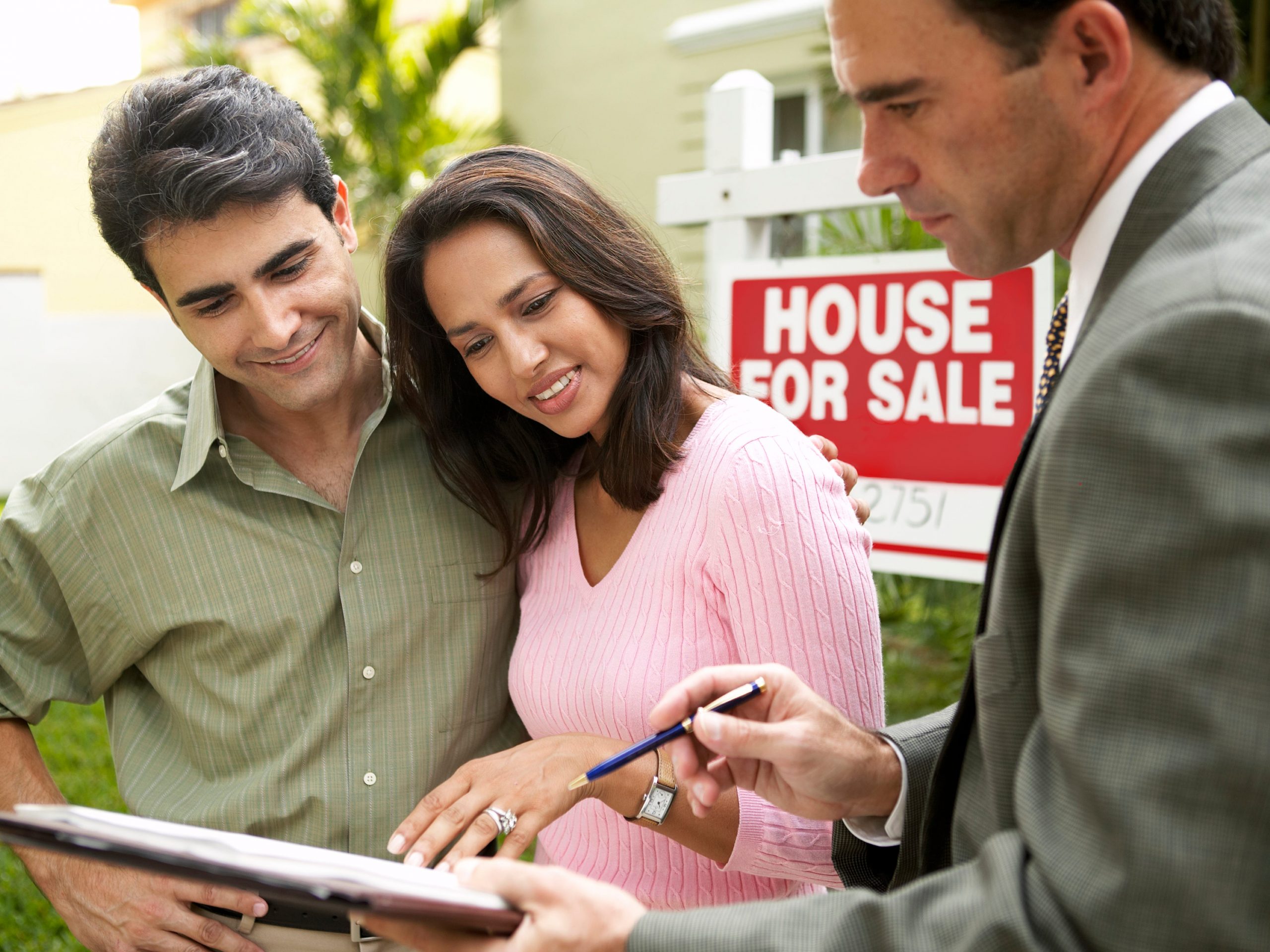 Couple and realtor signing papers for new house.