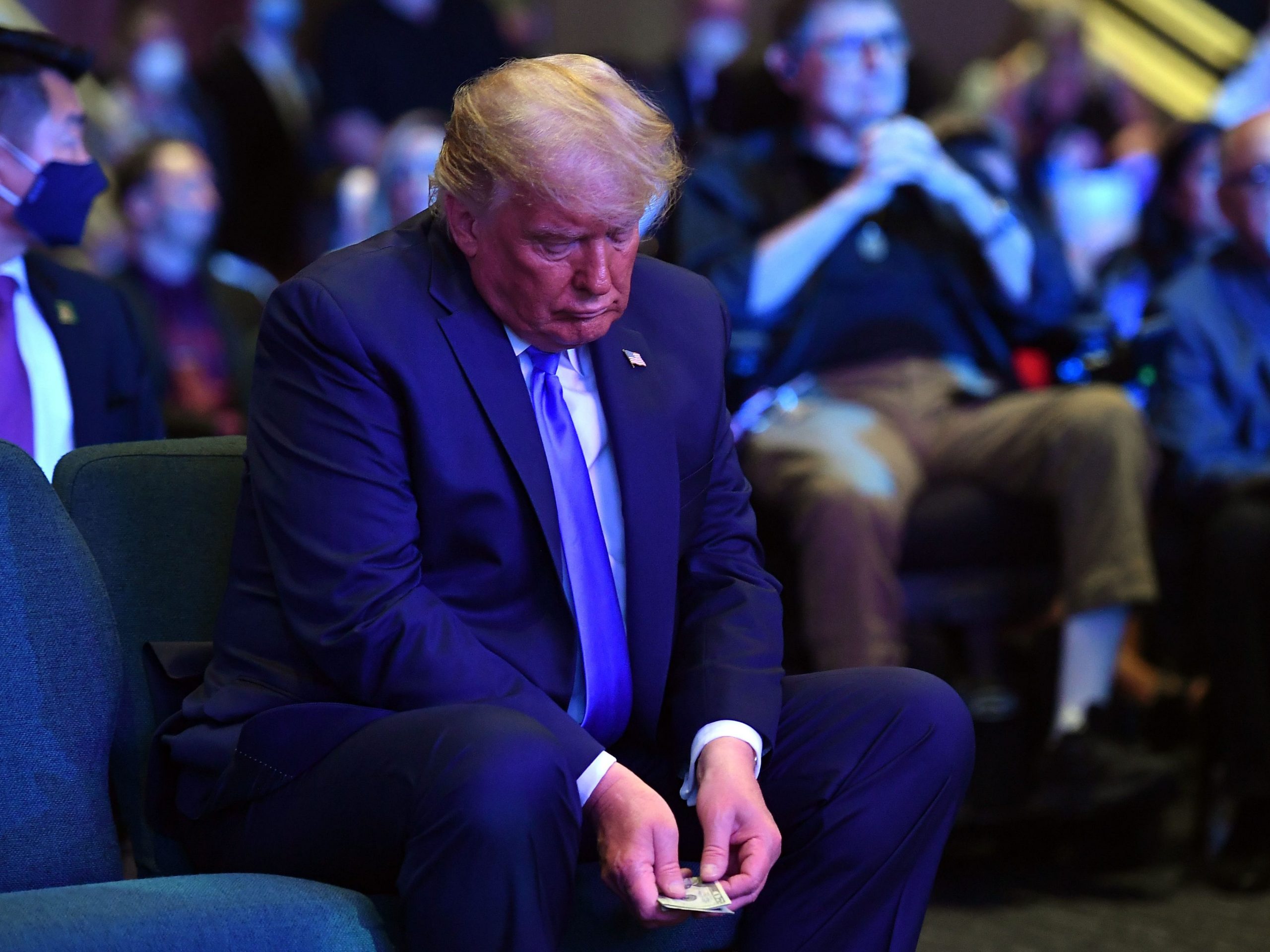 US President Donald Trump counts money before making an offering, as he attends services at the International Church of Las Vegas in Las Vegas, Nevada on October 18, 2020.