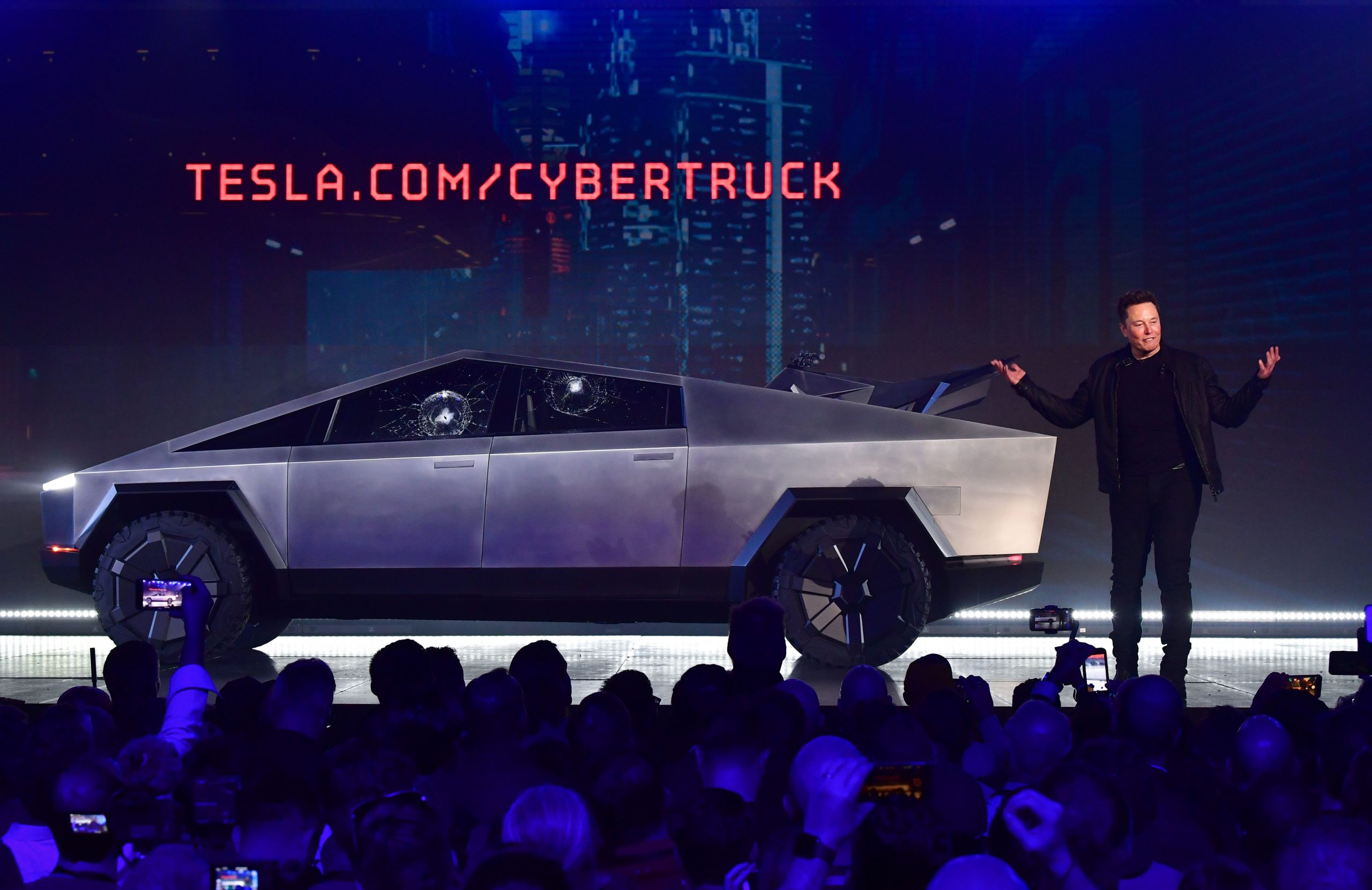 Tesla CEO Elon Musk speaks in front of the newly unveiled all-electric battery-powered Tesla's Cybertruck