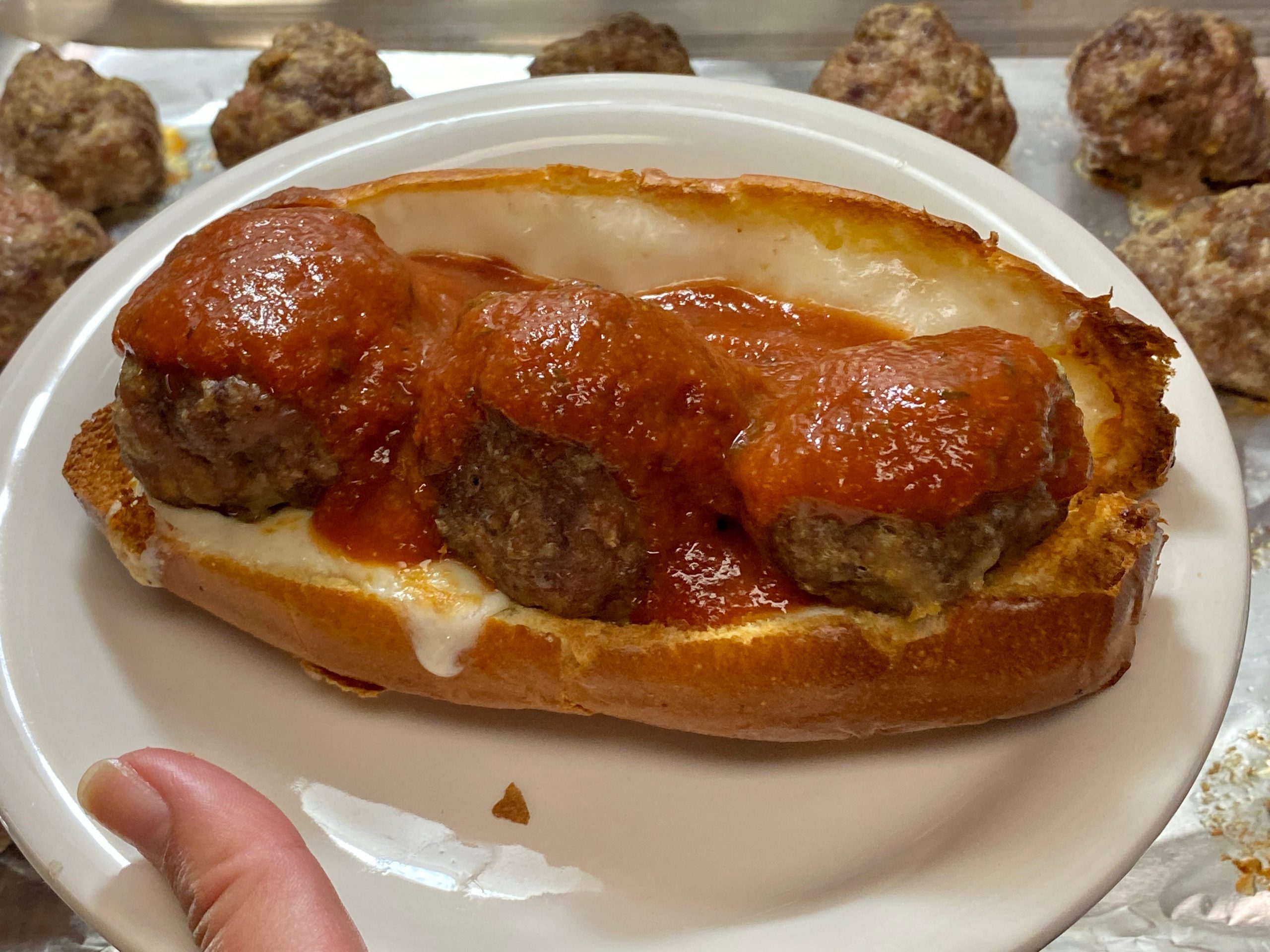 a homemade meatball sub on a white plate