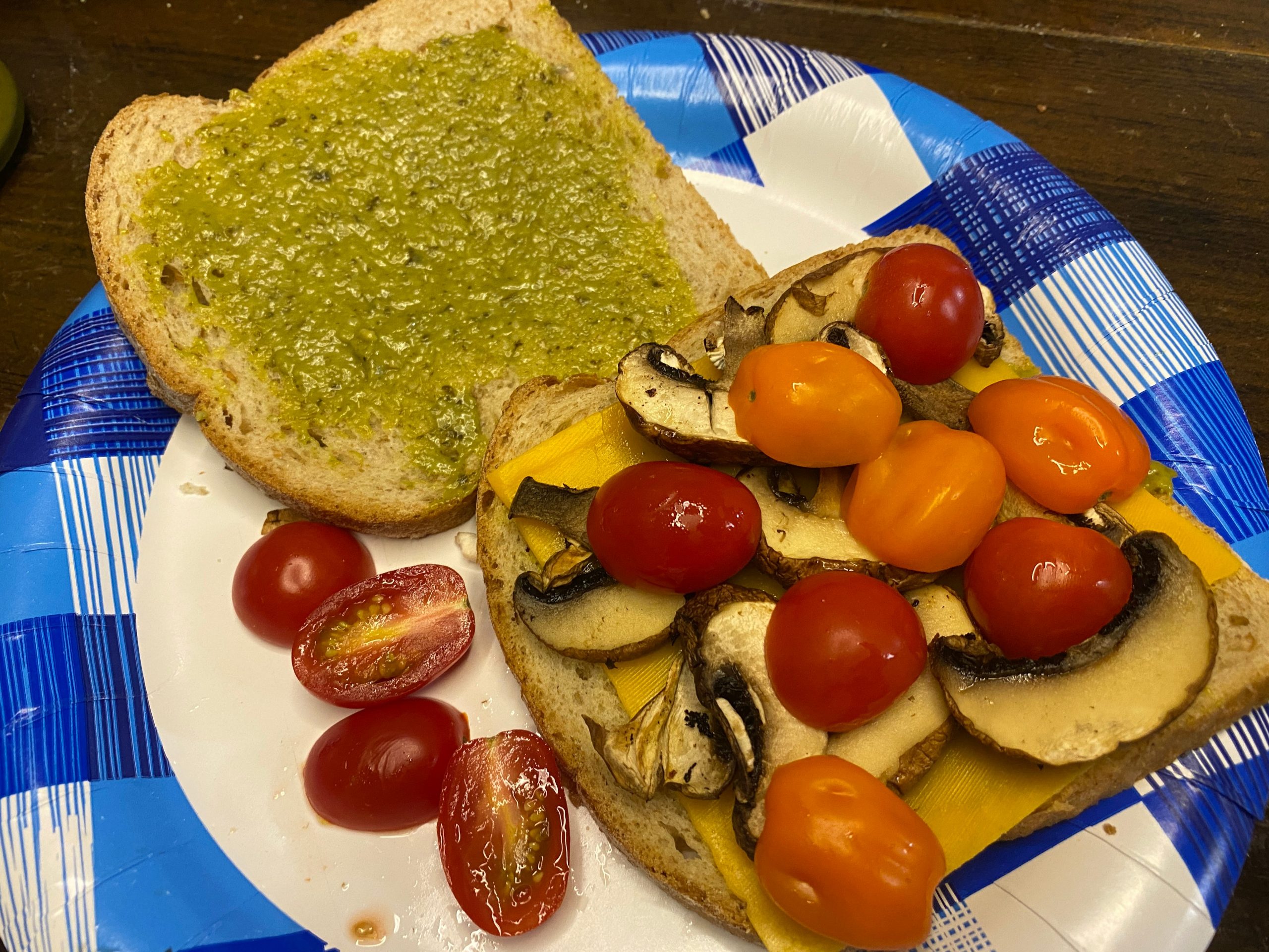 pesto, sliced cherry tomatoes, and mushrooms on bread