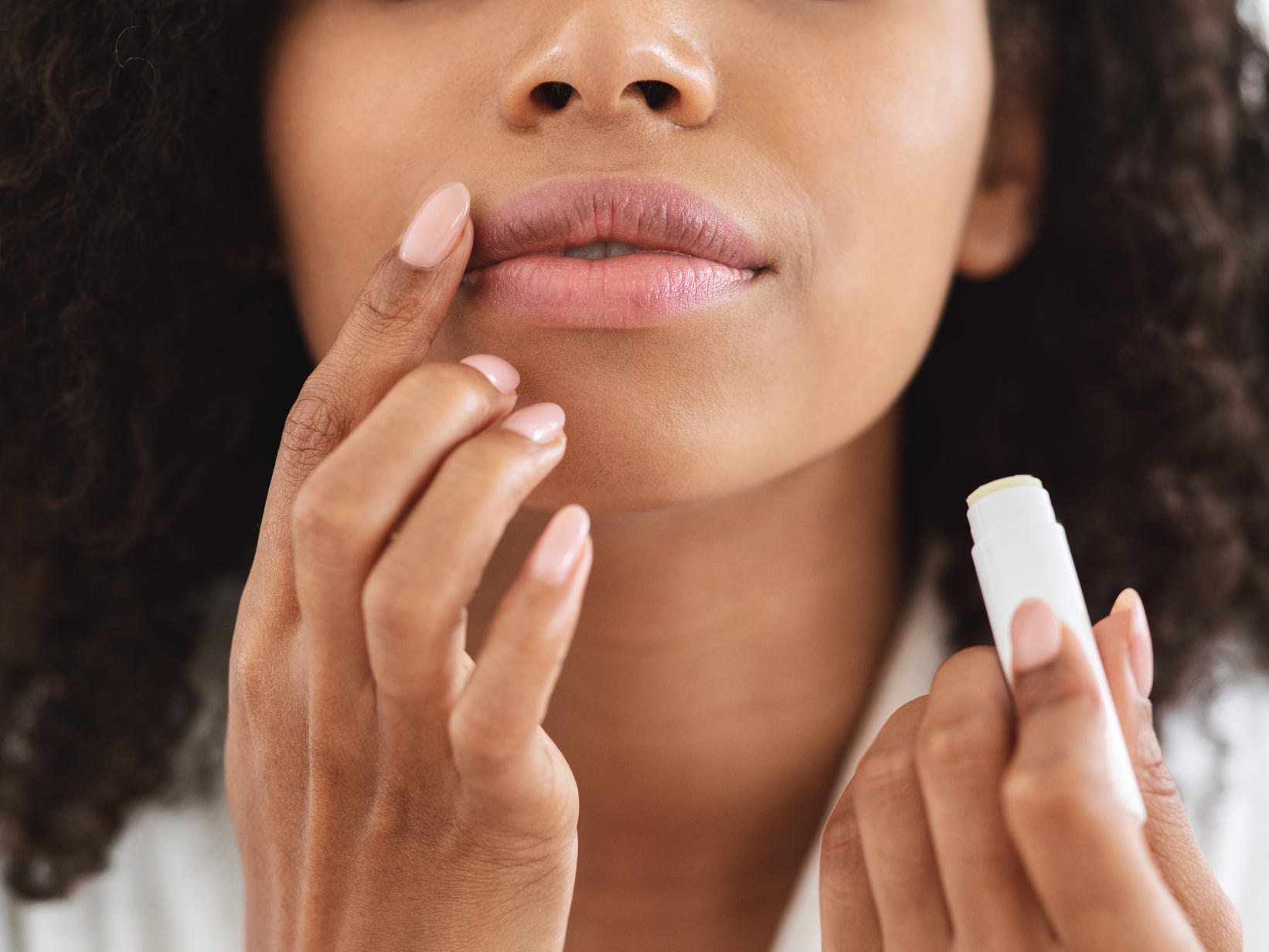 Person applies lip balm to their mouth