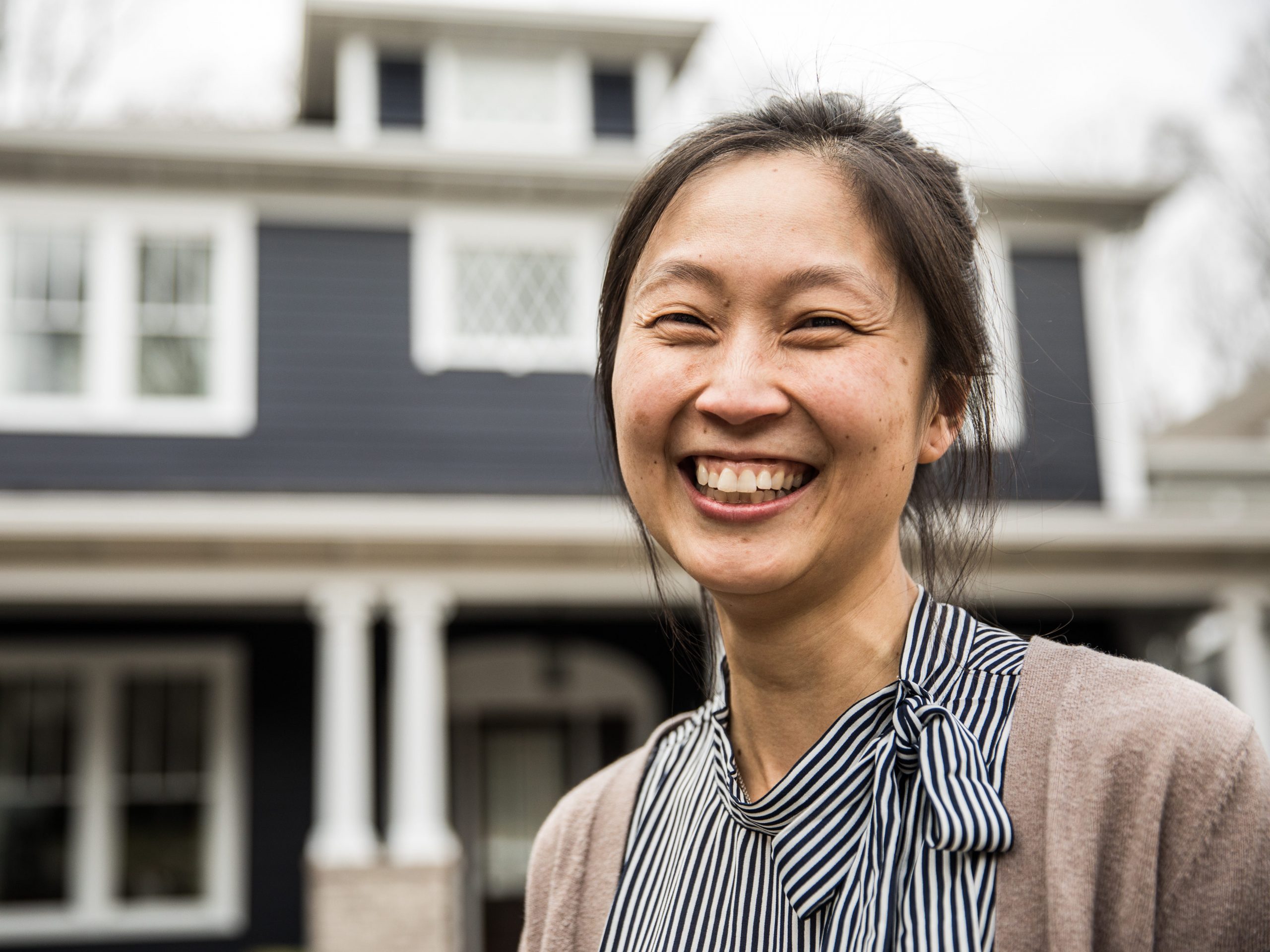 Woman smiling in front of house.