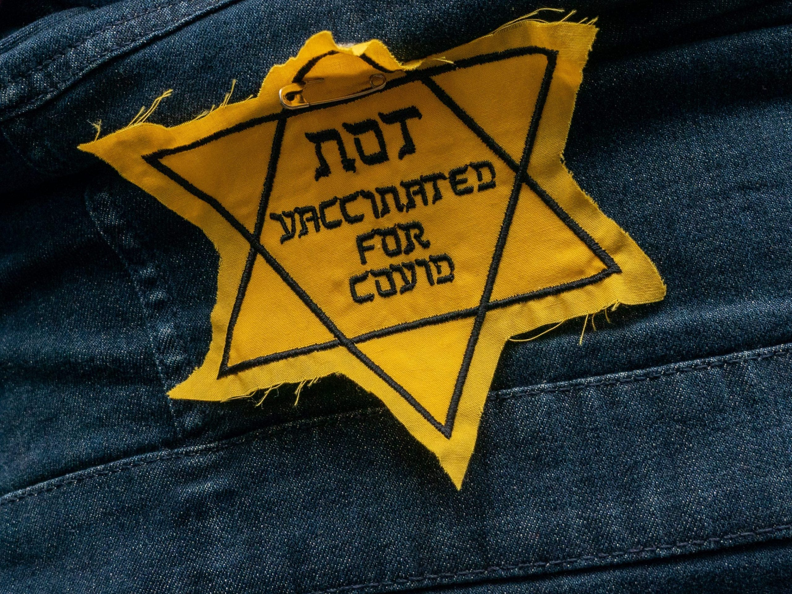Anti-vaccination patch resembling a Holocaust yellow star.