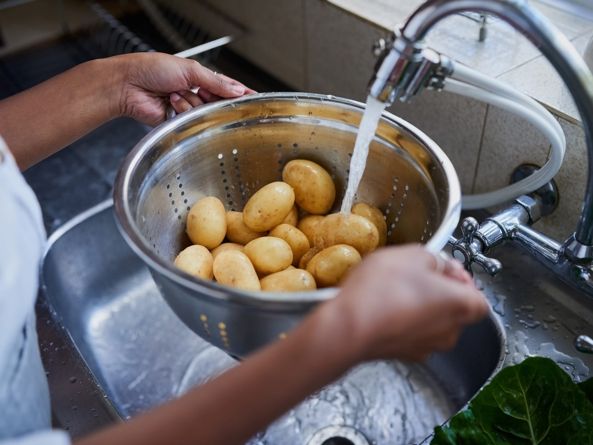 Person washing potatoes