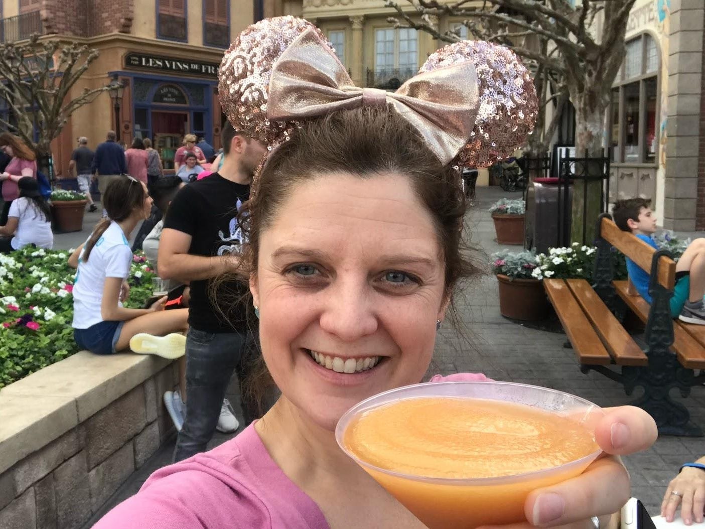 kari becker holding an orange drink in paris pavillion at epcot disney world